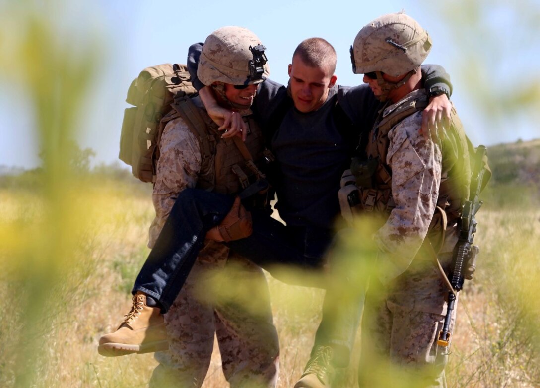 A Marine and corpsman with the 11th Marine Expeditionary Unit transport a role-player acting as an injured patient as part of a mass casualty training exercise during Certification Exercise (CERTEX) at Camp Pendleton, California, June 15, 2014. CERTEX serves as the final at-sea period for the 11th MEU and Amphibious Squadron 5. It is designed to strengthen the blue-green team's ability to operate together and to respond to various situations while deployed. (U.S. Marine Corps photo by Lance Cpl. Laura Y Raga/Released)