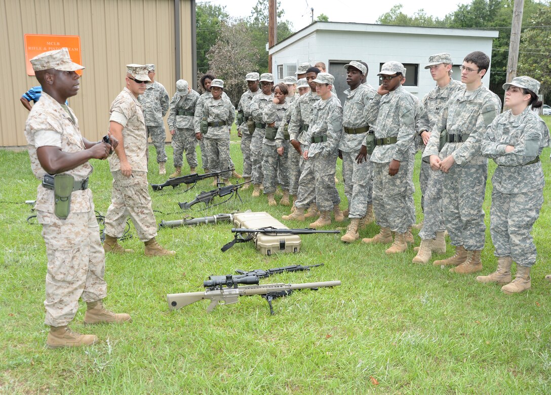 Sgt. Emal Britt, armory maintenance chief, Logistical Support Division (far left) and Sgt. Joshua M. Loflin, career planner, at Marine Corps Logistics Base Albany, identify the series type and use of several weapons to Army Junior Reserve Officers Training Corps cadets from Americus-Sumter High School, Americus, Ga., who attended a leadership training camp on the installation, June 3.
