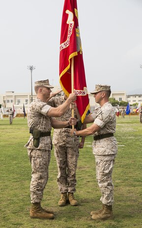 Lt. Col. F. Lance Lewis, right, passes the Headquarters and Headquarters Squadron colors to Lt. Col. Karl Schmidt during a change-of-command ceremony on the parade deck, June 9, 2014, aboard Marine Corps Air Station Iwakuni, Japan. Schmidt came to H&HS from U.S. Central Command aboard MacDill Air Force Base, Tampa, Fla.
