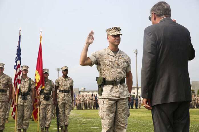 Lt. Col. F. Lance Lewis reaffirms his oath of enlistment during a change-of-command ceremony on the parade deck, June 9, 2014, aboard Marine Corps Air Station Iwakuni, Japan. Lewis’s father, Retired Rear Adm. Frederick L. Lewis, conducted the reaffirmation.