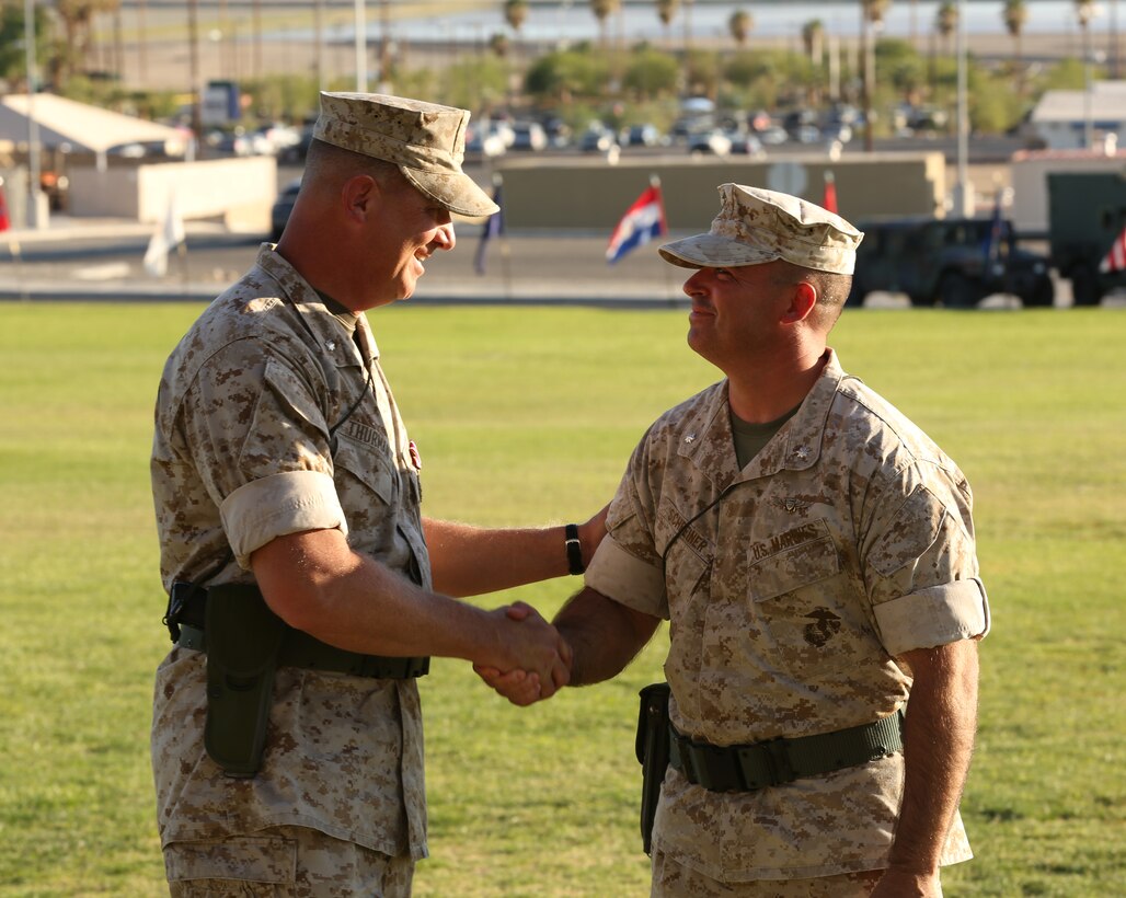 Lt. Col. John D. Thurman, former commanding officer, VMU-3, shakes hands with Lt. Col. Brynn H. Schreiner, commanding officer, Unmanned Aerial Vehicle Squadron 3, after the squadron's change of command ceremony at Lance Cpl. Torrey L. Gray Field, June 18, 2014. The change of command comes at a time when the squadron has officially designated Marine Corps Base Hawaii Kaneohe Bay, Hawaii, as its new headquarters.