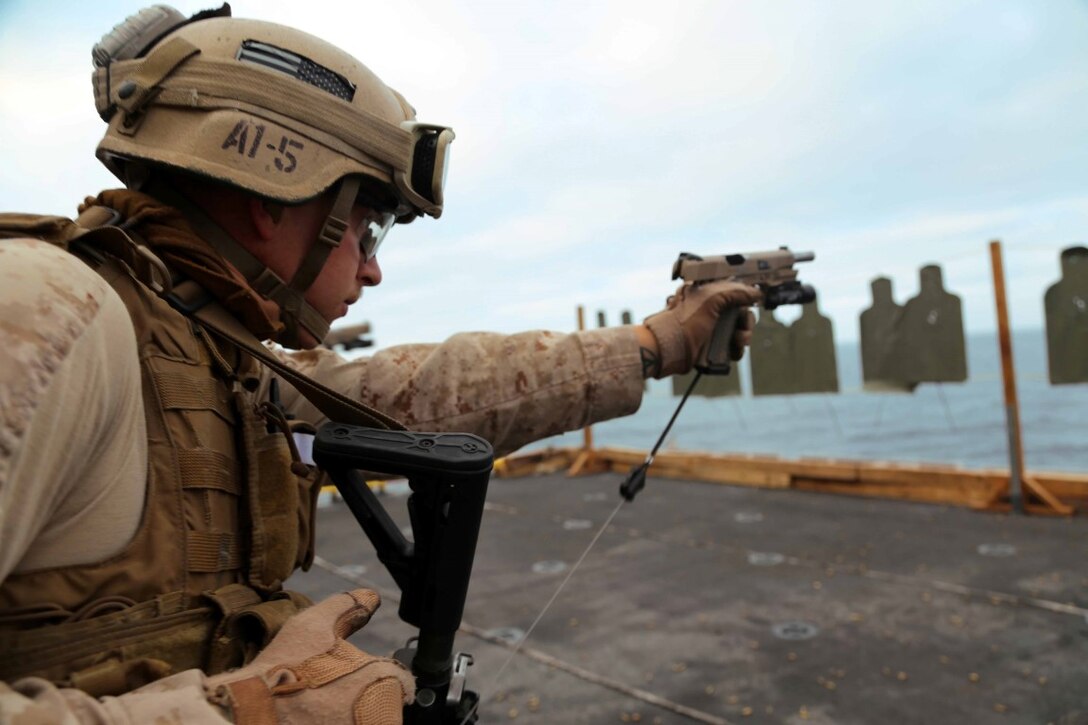 Sgt. Michael Currier, a Marine with the Force Reconnaissance Detachment, 11th Marine Expeditionary Unit, engages a target during a table two and three course of fire aboard the USS Makin Island during Certification Exercise (CERTEX) off the coast of Southern California, June 15, 2014. The 11th MEU and Amphibious Squadron 5 team conduct CERTEX to hone mission-essential tasks, execute specified MEU and Amphibious Ready Group operations, and certify the foundation of a cohesive warfighting team for exercises and operations they may encounter in their upcoming deployment. (U.S. Marine Corps photo by Lance Cpl. Laura Y Raga/Released)