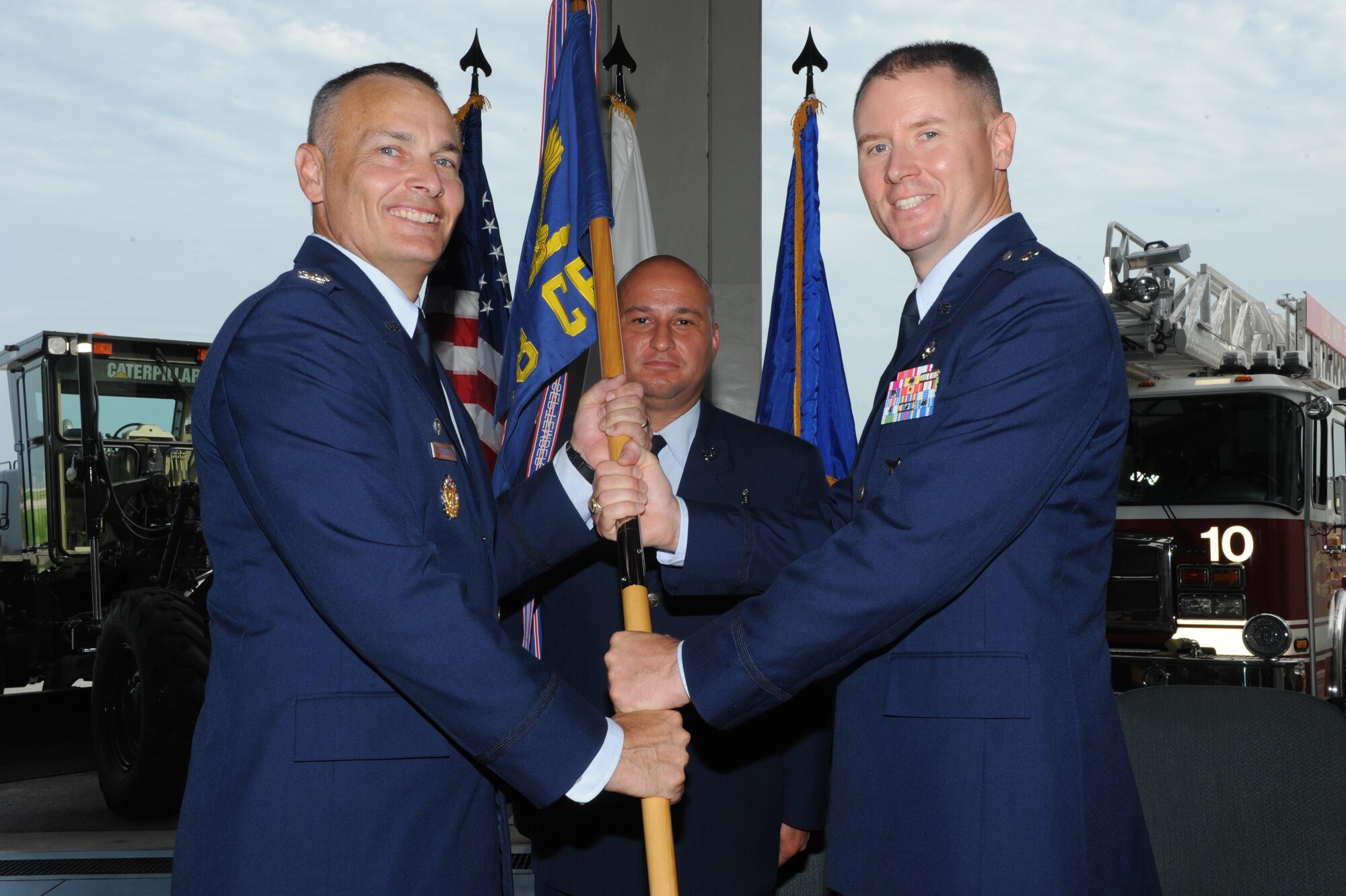 U.S. Air Force Col. Gary Schneider, 18th Civil Engineer Group commander, passes the 18th Civil Engineer Squadron guidon to Lt. Col. Aaron Brooks, the new 18th CES commander, during a change of command ceremony on Kadena Air Base, Japan, June 20, 2014. The moment Brooks received the guidon is the moment that he took full responsibility and command over the 18th CES. Brooks most recently served as the Deputy Chief of the Theatre Security Engagement Branch, Global Combat Support Division, Logistics, Installations and Mission Support Directorate at Headquarters Pacific Air Forces, Joint Base Pearl Harbor-Hickam, Hawaii. (U.S. Air Force photo by Airman 1st Class Stephen G. Eigel)
