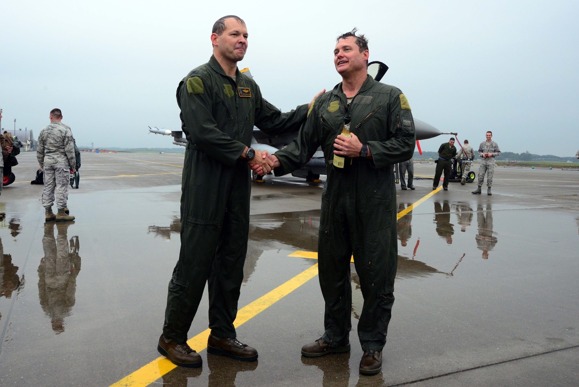 U.S. Air Force Col. Stephen Williams, left, 35th Fighter Wing commander, shakes hands with Col. Matthew Dana, 35 FW vice commander, after both pilots completed their fini-flights at Misawa Air Base, Japan, June 16, 2014. Fini-flight celebrations have evolved over time and now include champagne or similar, a toast and dowsing with water from a fire truck for the aircraft and aircrew. Usually, family or families of the departing aircrew or personnel also meet them on the flightline and douse them with water. (U.S. Air Force photo/Senior Airman Derek VanHorn)