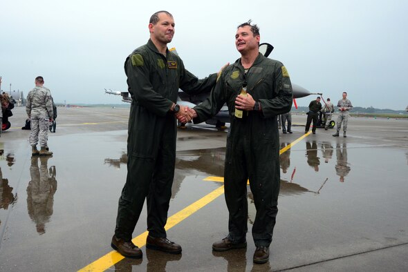 U.S. Air Force Col. Stephen Williams, left, 35th Fighter Wing commander, shakes hands with Col. Matthew Dana, 35 FW vice commander, after both pilots completed their fini-flights at Misawa Air Base, Japan, June 16, 2014. Fini-flight celebrations have evolved over time and now include champagne or similar, a toast and dowsing with water from a fire truck for the aircraft and aircrew. Usually, family or families of the departing aircrew or personnel also meet them on the flightline and douse them with water. (U.S. Air Force photo/Senior Airman Derek VanHorn)
