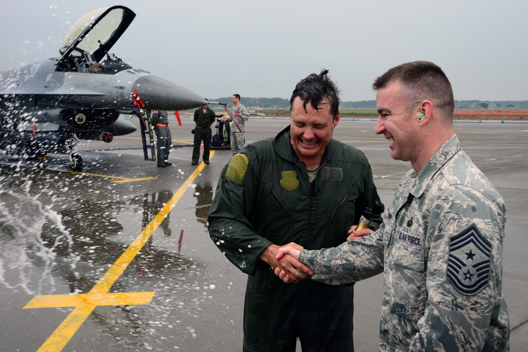 U.S. Air Force Col. Matthew Dana, 35th Fighter Wing vice commander, braces for a champagne celebration while shaking hands with Chief Master Sgt. Gary Sharp, 35 FW command chief, after completing his fini-flight at Misawa Air Base, Japan, June 16, 2014. Fini-flights were designed to accompany milestones in the career of the entire aircrew, respected individuals of rank or repute, or a commander's departure to another command or retirement. (U.S. Air Force photo/Senior Airman Derek VanHorn)