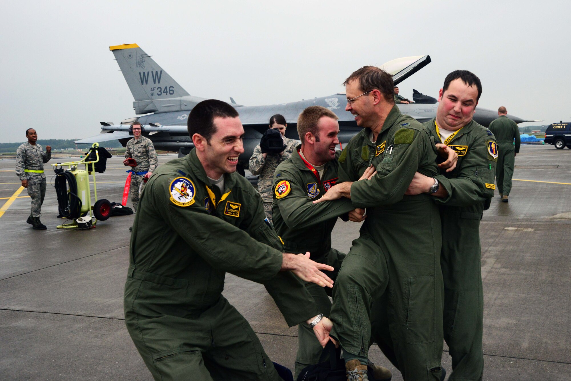 U.S. Air Force Col. Stephen Williams, 35th Fighter Wing commander, is aggressively met by three 35 FW pilots after completing his fini-flight at Misawa Air Base, Japan, June 16, 2014. A pilot’s fini-flight has become a U.S. Air Force tradition, and celebrates milestones with champagne or similar, a toast and dowsing with water from a fire truck for the aircraft and aircrew. Usually, family or families of the departing aircrew or personnel also meet them on the flightline and douse them with water. (U.S. Air Force photo/Senior Airman Derek VanHorn)