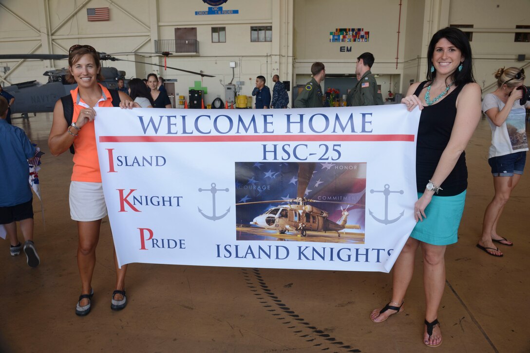 Family members of Helicopter Sea Combat Squadron 25 Detachment 6 await the arrival of their Sailors during the HSC-25 Det. 6 homecoming  June 13, 2014, on Andersen Air Force Base, Guam. Det. 6 supported the U.S. Navy 7th Fleet in the Western Pacific area of responsibility during a six-month deployment aboard USS Bonhomme Richard. (U.S. Air Force photo by Airman 1st Class Adarius Petty/Released)