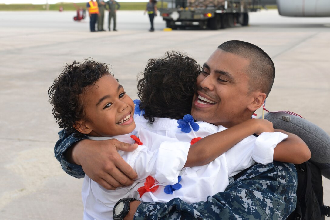U.S. Navy Petty Officer 2nd Class James Wardrobe, Helicopter Sea Combat Squadron 25 Detachment 6 aviation electrician, hugs his sons during the unit’s homecoming  June 13, 2014, on Andersen Air Force Base, Guam. Det. 6 supported the U.S. Navy 7th Fleet in the Western Pacific area of responsibility during a six-month deployment aboard USS Bonhomme Richard. (U.S. Air Force photo by Airman 1st Class Adarius Petty/Released)