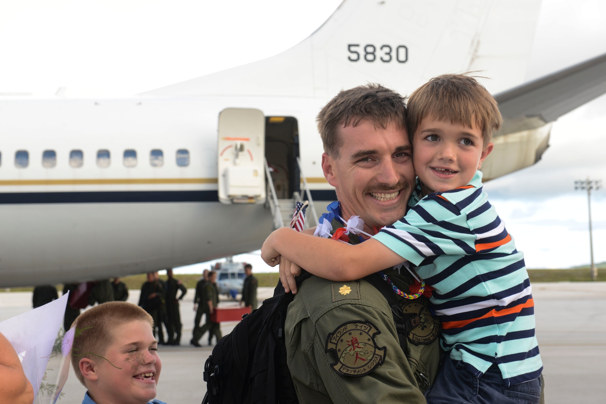 U.S. Navy Lt. Cmdr. David Williams, Helicopter Sea Combat Squadron 25 Detachment 6 officer in charge, hugs his sons during the unit’s homecoming  June 13, 2014, on Andersen Air Force Base, Guam. Det. 6 supported the U.S. Navy 7th Fleet in the Western Pacific area of responsibility during a six-month deployment aboard USS Bonhomme Richard. (U.S. Air Force photo by Airman 1st Class Adarius Petty/Released)