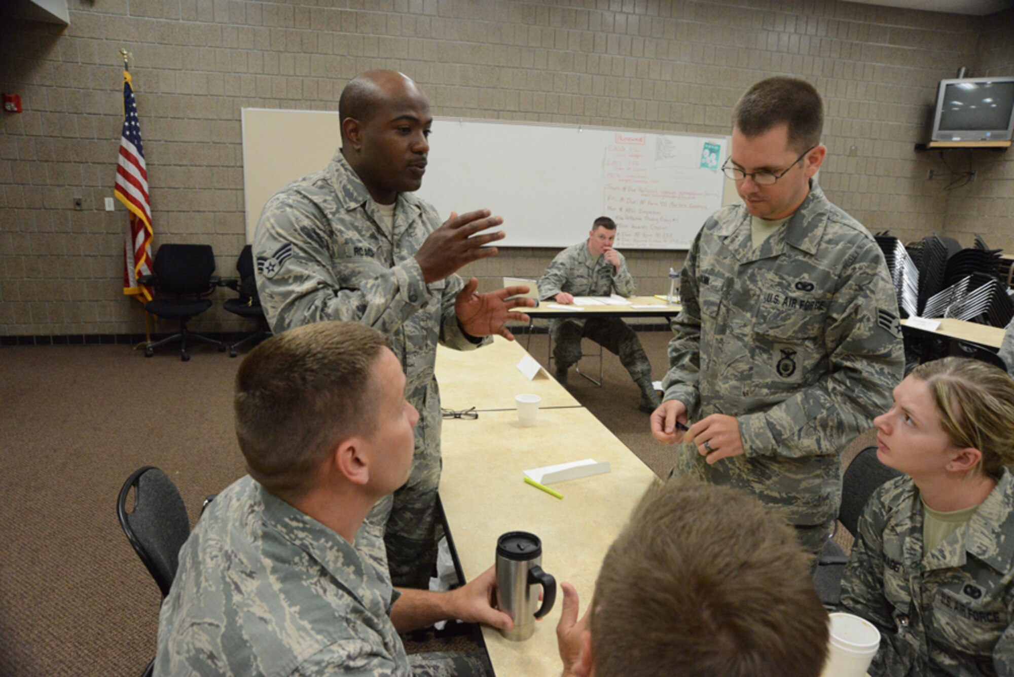 Senior Airman Roy Roach III, of the North Dakota Air National Guard’s 119th Medical Group, standing left, offers an opinion for group discussion during an Airman Leadership School class at Guard’s Air Base, Fargo, N.D., June 12, 2014, as instructor Tech. Sgt. James Richey monitors the activity on the background. The six-week ALS course is among the first in the country being offered by active-duty instructors at an Air National Guard base. Instructors traveling to students’ location are a cost effective way of conducting training. (U.S. Air Force photo/Senior Master Sgt. David H. Lipp))