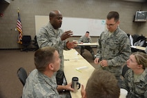 Senior Airman Roy Roach III, of the North Dakota Air National Guard’s 119th Medical Group, standing left, offers an opinion for group discussion during an Airman Leadership School class at Guard’s Air Base, Fargo, N.D., June 12, 2014, as instructor Tech. Sgt. James Richey monitors the activity on the background. The six-week ALS course is among the first in the country being offered by active-duty instructors at an Air National Guard base. Instructors traveling to students’ location are a cost effective way of conducting training. (U.S. Air Force photo/Senior Master Sgt. David H. Lipp))