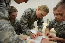 Senior Airman Sophie Miller, of the North Dakota Air National Guard’s 119th Civil Engineer Squadron, center, writes a group answer to an Airman Leadership School question during a knowledge based classroom contest at the Guard’s Air Base, Fargo, N.D., June 12, 2014. The six-week ALS course is among the first in the country being offered by active-duty instructors at an Air National Guard base. Instructors traveling to students’ location are a cost effective way of conducting training. (U.S. Air Force photo/Senior Master Sgt. David H. Lipp)