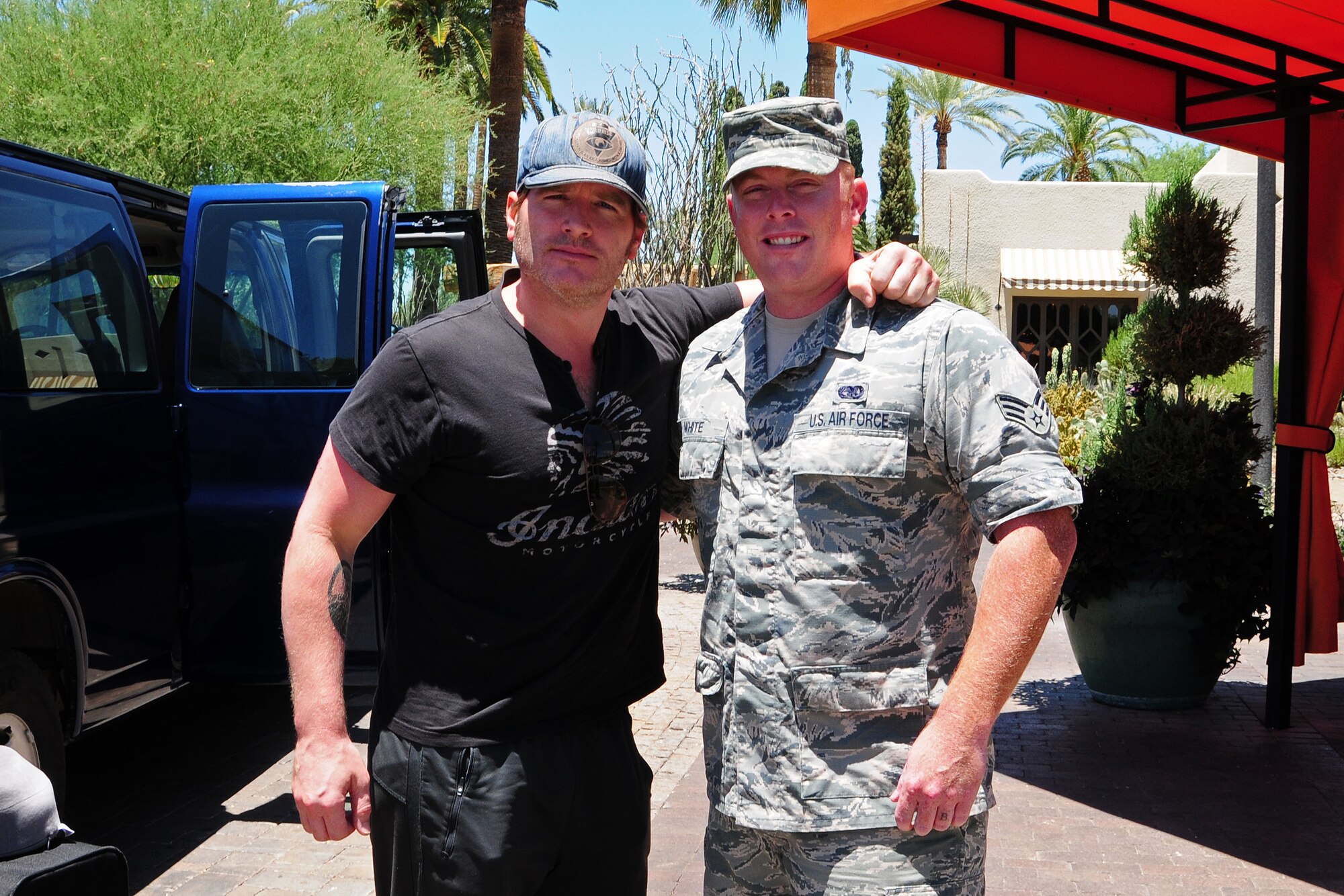 Jerrod Niemann, country music singer, poses with Senior Airman Christopher White, 944th Logistics Readiness Squadron vehicle operations, June 19 at the Wigwam Resort before the Salute to the Troops live concert at Luke Air Force Base, Ariz. (U.S. Air Force photo taken by Tech. Sgt. Louis Vega Jr.)