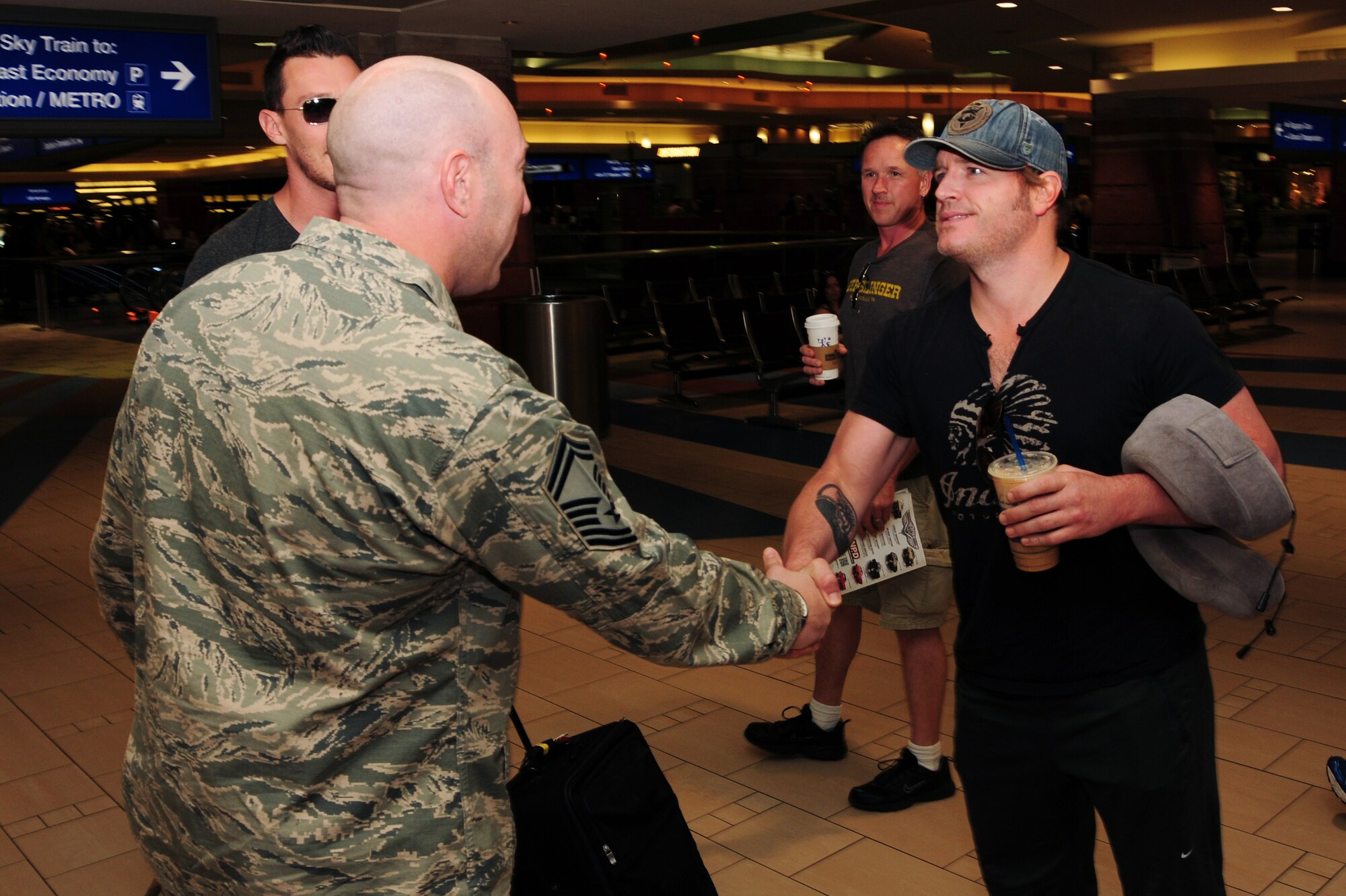 Jerrod Niemann, country music singer, shakes hands with Senior Master Sgt. Adam Ura, 944th Civil Engineer Squadron, June 19 as he arrives at Sky Harbor International Airport, Phoenix, Ariz. (U.S. Air Force photo taken by Tech. Sgt. Louis Vega Jr.)