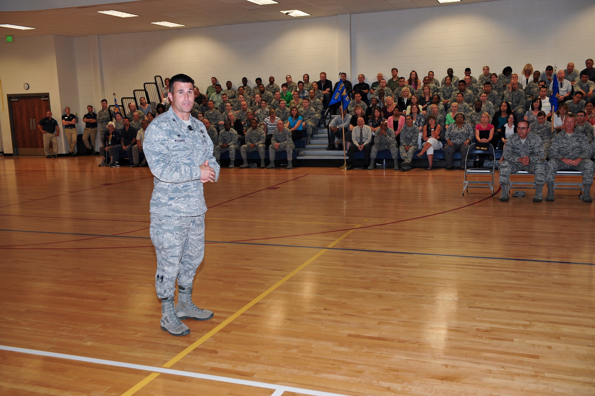 Col. John Wagner, 460th Space Wing commander, left, speaks to the men and women of Team Buckley where he presented his expectations and goals for his coming term June 18, 2014, at the fitness center on Buckley Air Force Base, Colo. Wagner assumed command of the 460th SW after serving in several space-based positions across the Air Force. (U.S. Air Force photo by Senior Airman Phillip Houk/Released)