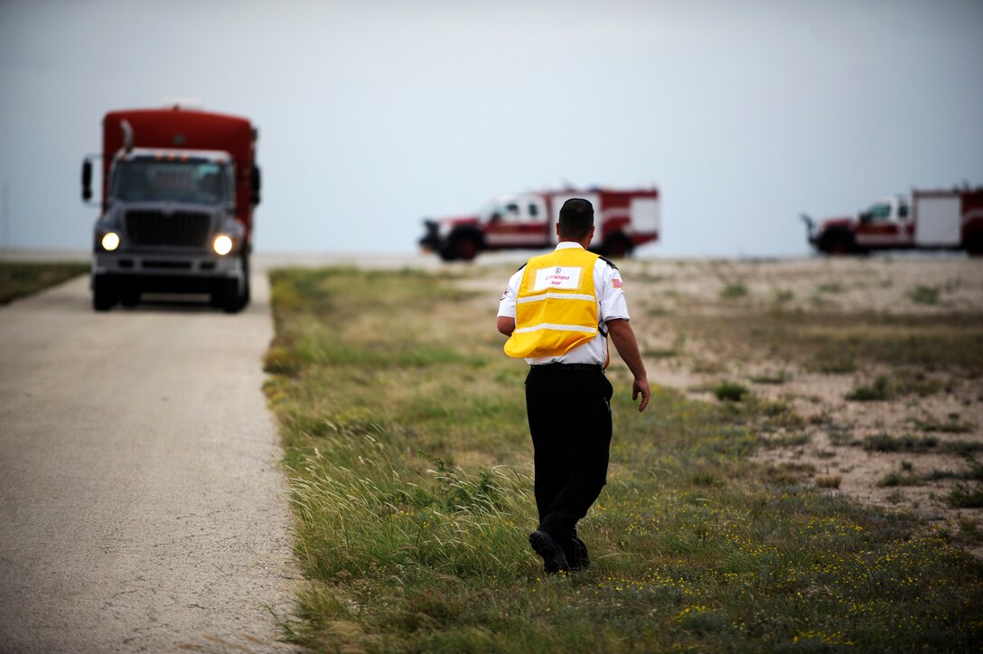 Olin Jensen, 47th Civil Engineer Squadron station captain and training operations chief, directs emergency response vehicles for a joint unit response training event on Laughlin Air Force Base, Texas, June 17, 2014. Jensen was responsible for directing all the actions of the event, set by the incident commander, to meet the incident objectives. (U.S. Air Force photo/Staff Sgt. Steven R. Doty)(Released)