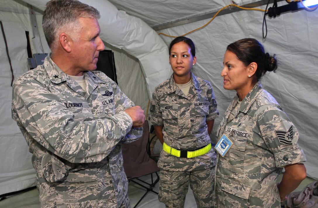 Brig. Gen. John Flournoy, commander, 4th Air Force, Air Force Reserve Command, visits with technical sergeants Camille Moore, center, and Alicia Yi, both with the 932nd Aeromedical Staging Squadron, during a medical field exercise June 19, 2014 at Scott Air Force Base.  (U.S. Air Force photo by Tech. Sgt. Christopher Parr)