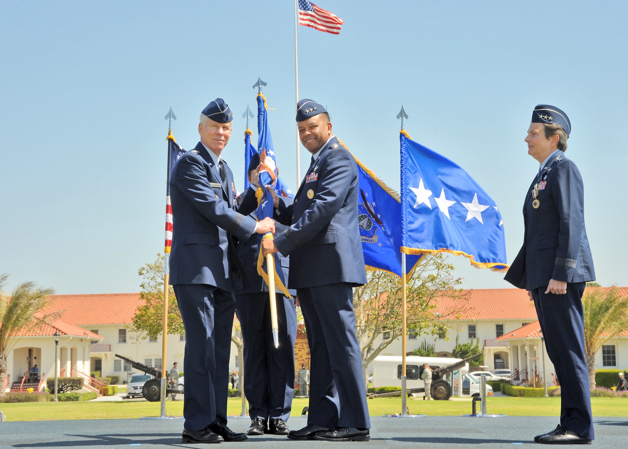 General William Shelton (left), Air Force Space Command commander, passes the Space and Missile Systems Center flag to Lieutenant General Samuel Greaves, incoming SMC commander, while Lieutenant General Ellen Pawlikowski (right), outgoing SMC commander, looks on.