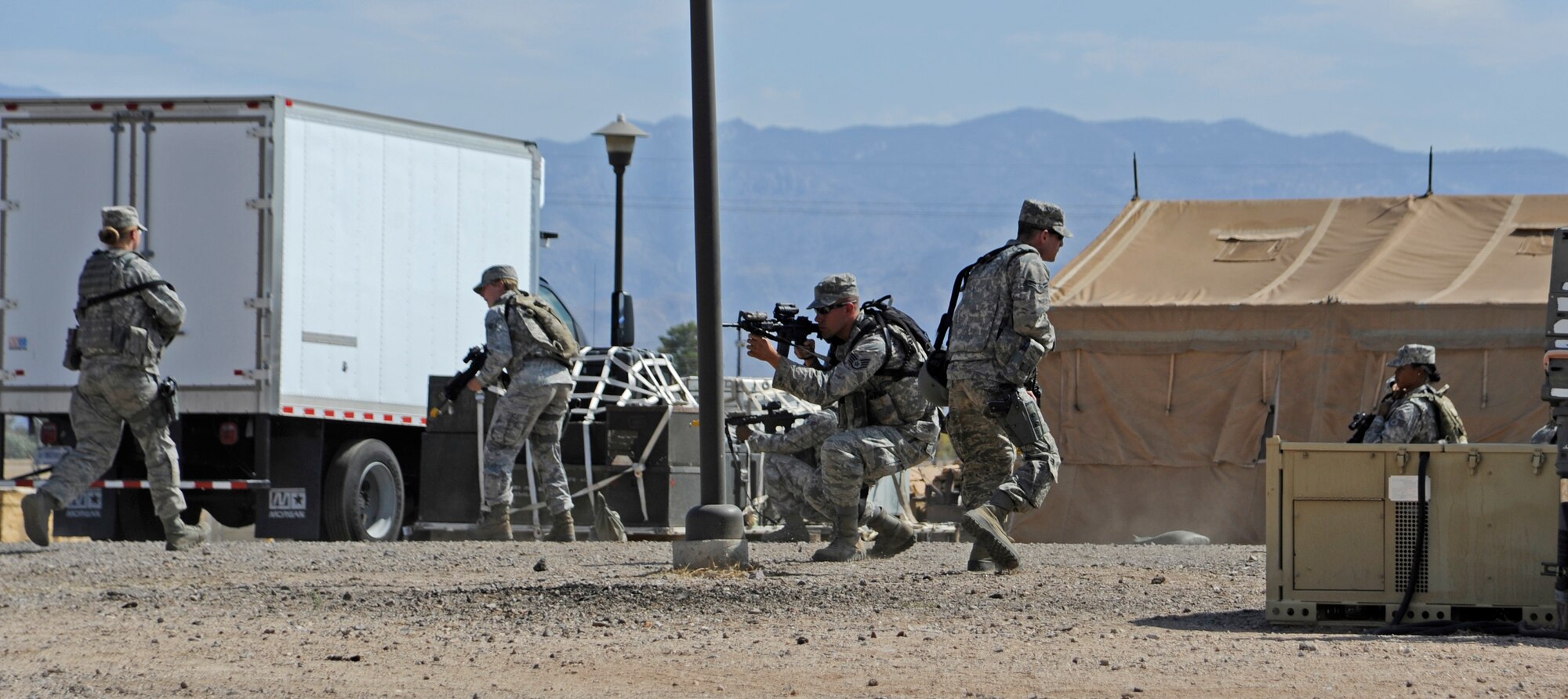 Members of the 355th Security Forces Squadron perform defensive drills while conducting a perimeter patrol of Base-X during Phase II of an Operational Readiness Exercise at Davis-Monthan Air Force Base, Ariz., June 17, 2014. This type of exercise focuses on how Airmen respond during simulated attacks and helps the base prepare Airmen for deployed operations. (U.S. Air Force photo by Airman 1st Class Betty R. Chevalier/Released)