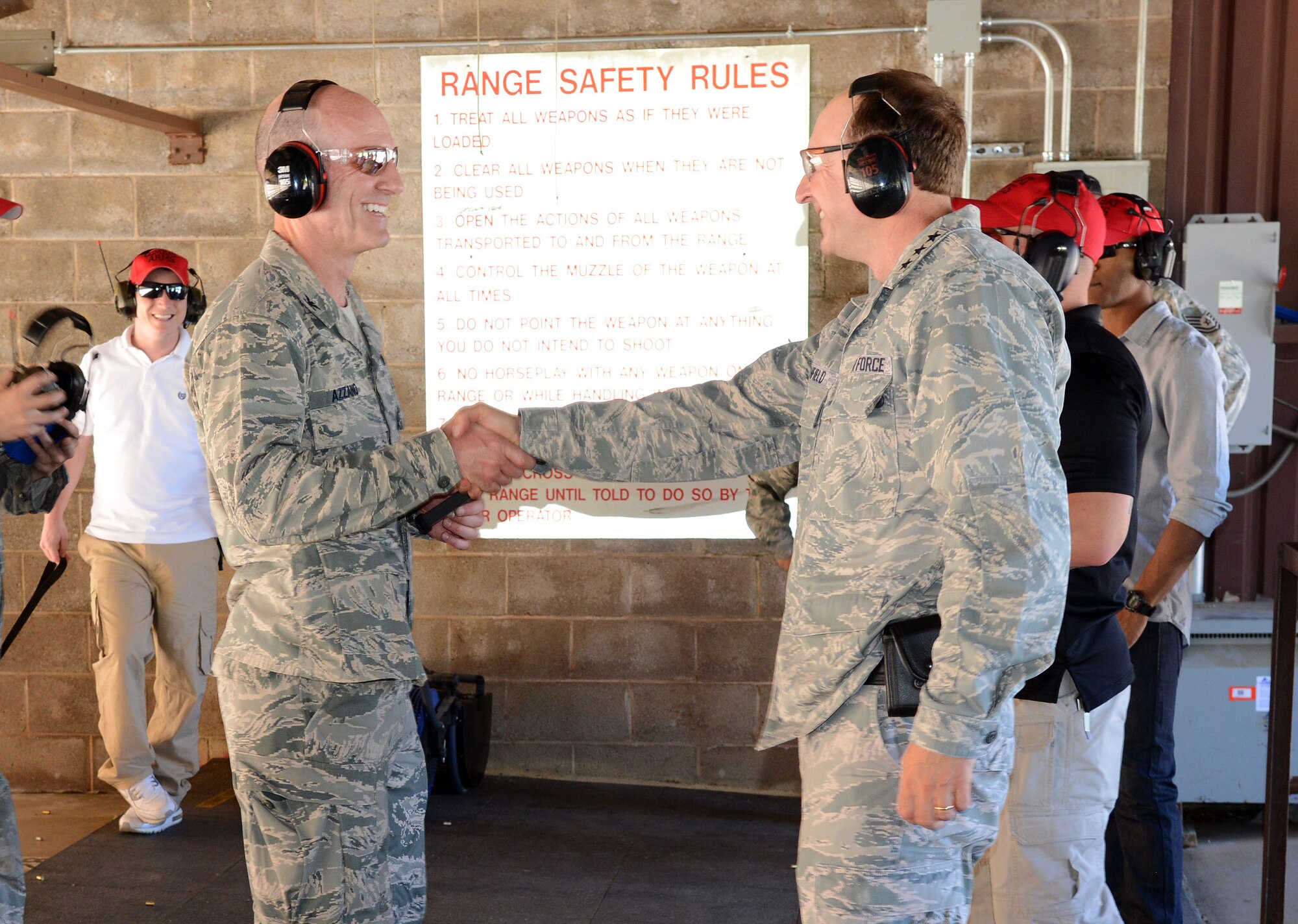 Air Force Sustainment Center Commander, Lt. Gen. Bruce Litchfield, extends a courteous handshake to 72nd Air Base Wing and Tinker Installation Commander Col. Christopher Azzano after a friendly shooting competition at the CATM gun range last Friday. (Air Force photo by Kelly White)
