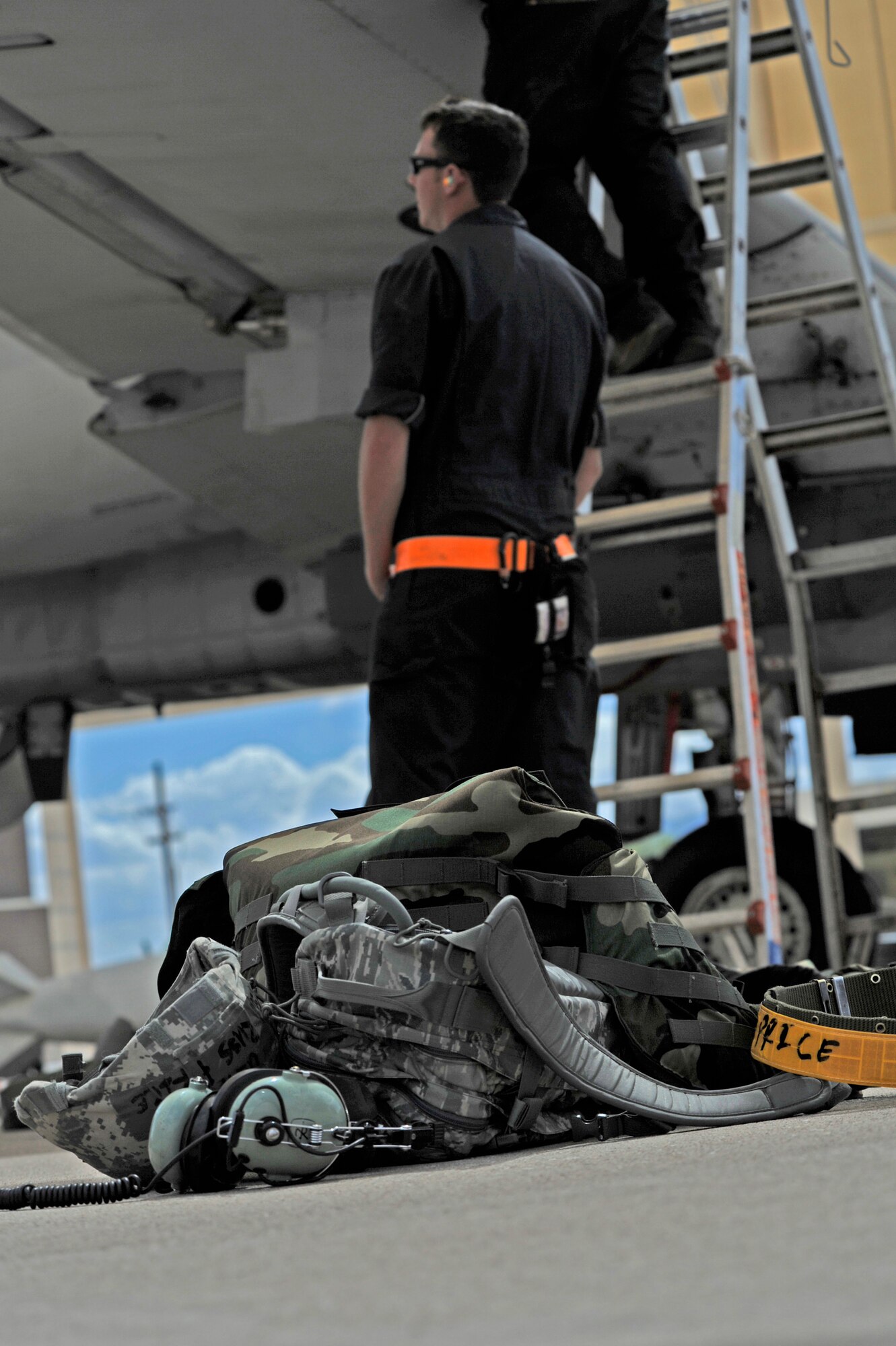Individual protective equipment lays on the flightline while members of the 354th Aircraft Maintenance Unit work on an A-10C Thunderbolt II during an Operational Readiness Exercise at Davis-Monthan Air Force Base, Ariz., June 18, 2014. Maintenance personnel were tested on their capability to maintain and generate aircraft for takeoff while surviving during fluctuating force protection conditions. (U.S. Air Force photo by Airman 1st Class Betty R. Chevalier/Released)