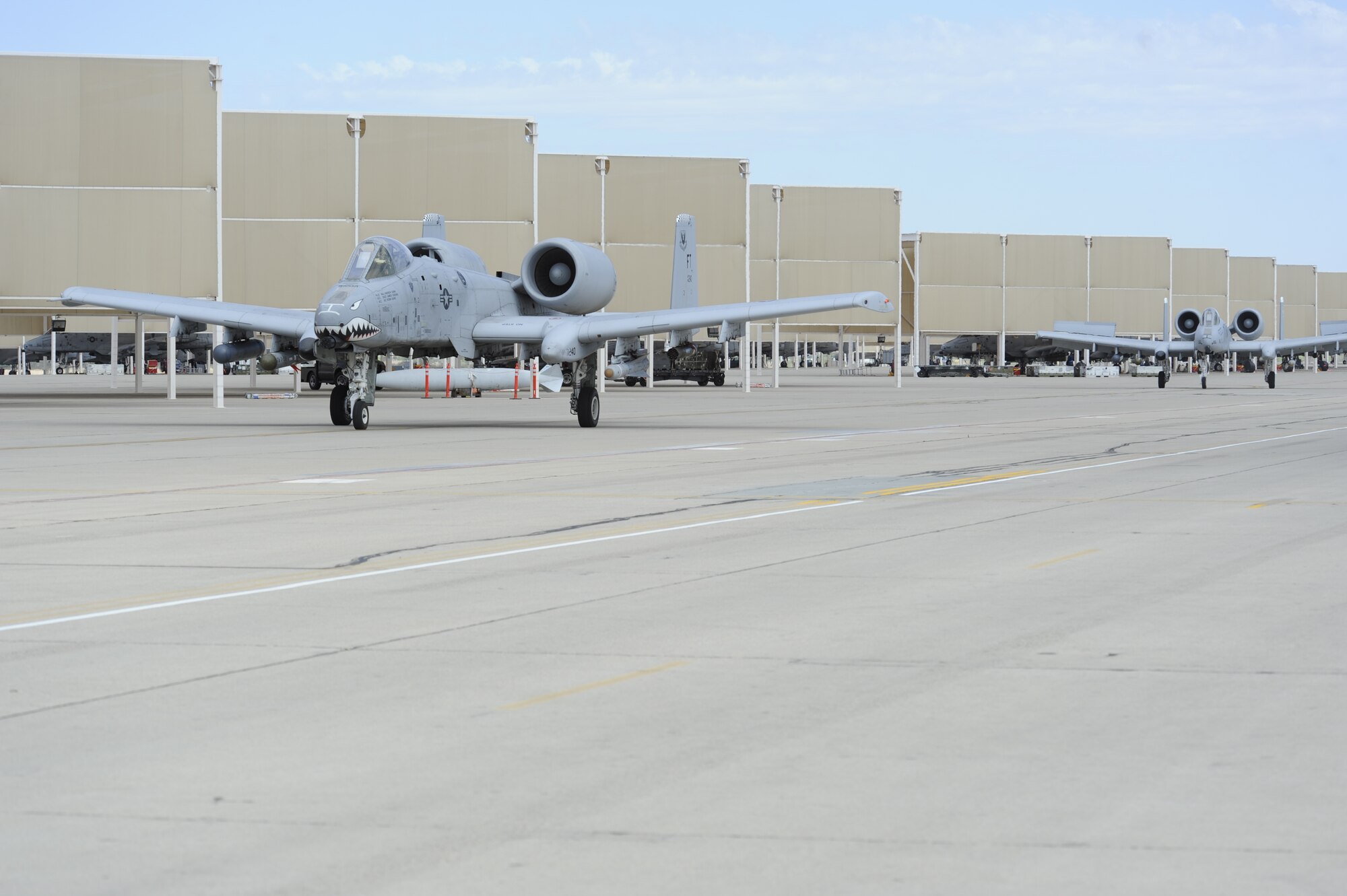 Two A- 10C Thunderbolt II’s taxi under sunshades after landing at Davis-Monthan Air Force Base, Ariz., June 18, 2014. The ORE was designed to test the base’s ability to conduct operations in a deployed environment. (U.S. Air Force photo by Airman 1st Class Betty R. Chevalier/Released)