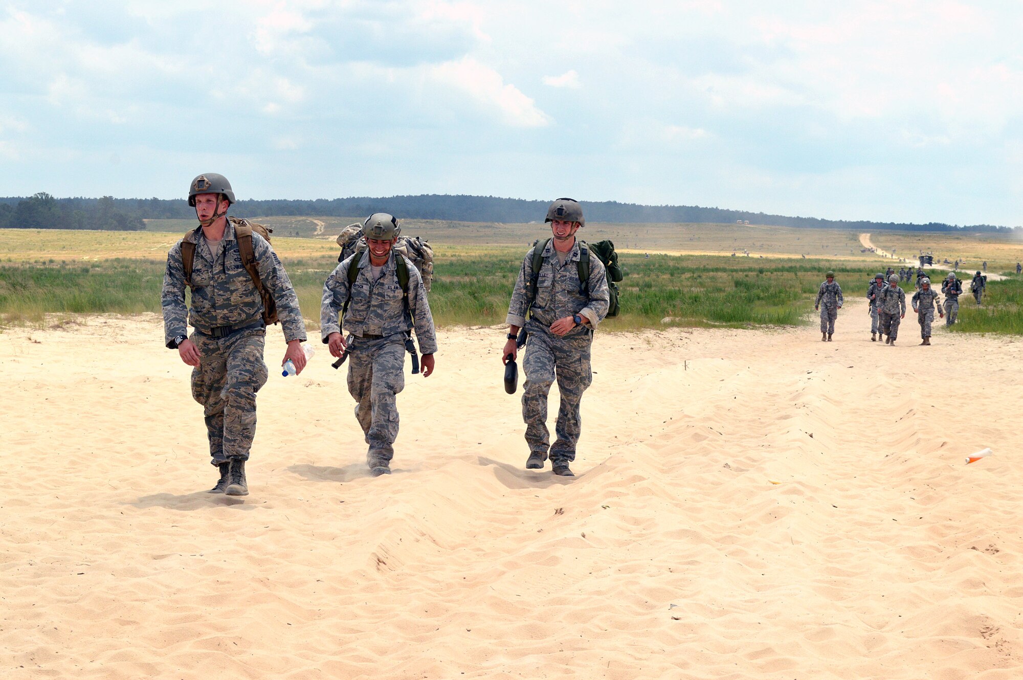 Staff Sgt. Erik Dowling, 18th Weather Squadron, left, Senior Airman Nicholas Bertsch, 14th Air Support Operations Squadron, center, and Capt. Charles Polley, 14th Air Support Operations Squadron, right, walk from Fort Bragg’s Normandy Drop Zone after a static-line parachute jump from an Air Force C-130 Hercules aircraft on June 6, 2014, to commemorate the 70th anniversary of D-Day. Forty Tactical Air Control Party and Battlefield Weather Airmen jumped with over 300 paratroopers from the 27th Engineer Battalion (C) (A) and 82nd Sustainment Brigade, commemorating the paratroopers who jumped into France on June 6, 1944 to begin the push into Europe to defeat the German Army during World War II. (U.S. Air Force photo/Marvin Krause)