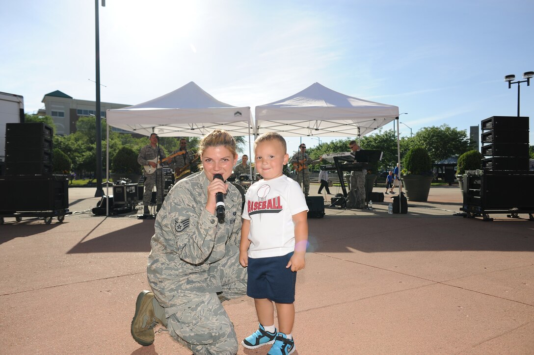 SSgt Kelley Perry sings to a young baseball fan at Dayton's Fifth Third Stadium in June 2014.  The Systems Go band provided entertainment for baseball fans entering the stadium on Hometown Heroes military appreciation day.  Systems Go is a part of the USAF Band of Flight, stationed at Wright-Patterson AFB, Ohio.