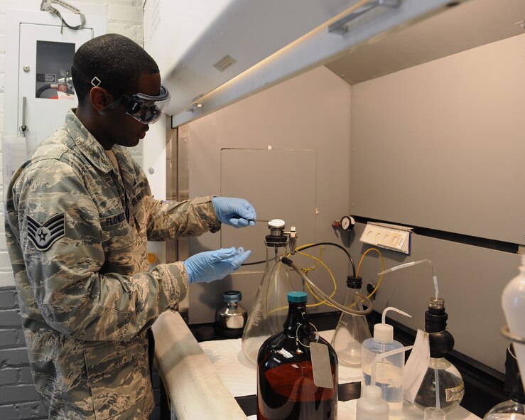 Staff Sgt. Jason Flowers, 2nd Logistics Readiness Squadron fuels laboratory technician, places a membrane filter on a bottling assembly at Barksdale Air Force Base, La., June 18, 2014. Fuel is poured through the membrane filter, leaving particles inside the fuel on the filter. Technicians will measure the weight of the membrane filter before the process and after to check the difference in weight. A large difference indicates the fuel has too much particles inside of it. (U.S. Air Force photo/Senior Airman Benjamin Gonsier)