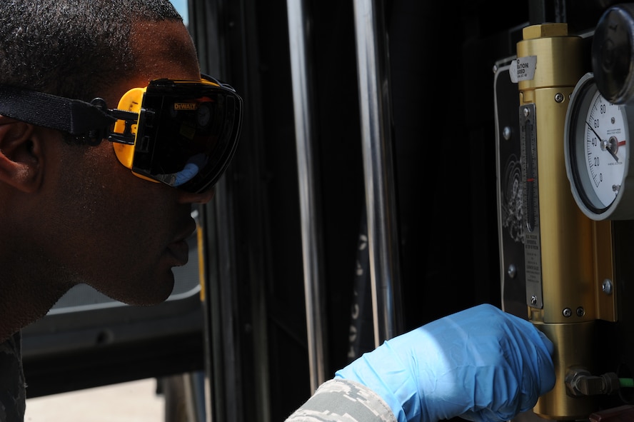 Staff Sgt. Jason Flowers, 2nd Logistics Readiness Squadron fuels laboratory technician, checks the differential pressure gauge on an R-11 fuel truck at Barksdale Air Force Base, La., June 18, 2014. As fuel is being transferred through the filter, the differential pressure gauge will show the difference in pressure before and after it is transferred through the filter. A large difference indicates that the filters are either clogged up or the fuel has too many particles inside of it. (U.S. Air Force photo/Senior Airman Benjamin Gonsier)