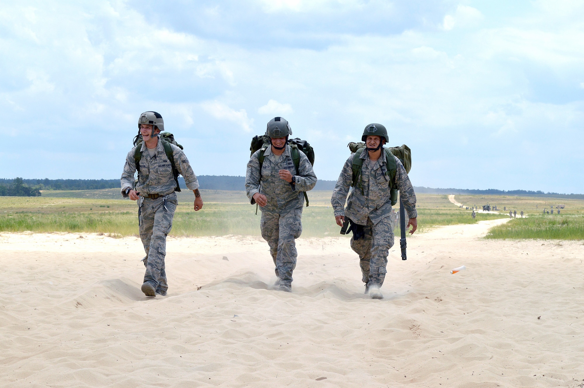 Airman 1st Class Patrick Covington II, left, Airman 1st Class Giovan Vitale, center, and Senior Airman Oscar Robles, right, all from the 14th Air Support Operations Squadron, walk from Fort Bragg’s Normandy Drop Zone after a static-line parachute jump from an Air Force C-130 Hercules aircraft on June 6, 2014, to commemorate the 70th anniversary of D-Day. Forty Tactical Air Control Party and Battlefield Weather Airmen jumped with over 300 paratroopers from the 27th Engineer Battalion (C) (A) and 82nd Sustainment Brigade, commemorating the paratroopers who jumped into France on June 6, 1944 to begin the push into Europe to defeat the German Army during World War II. (U.S. Air Force photo/Marvin Krause)