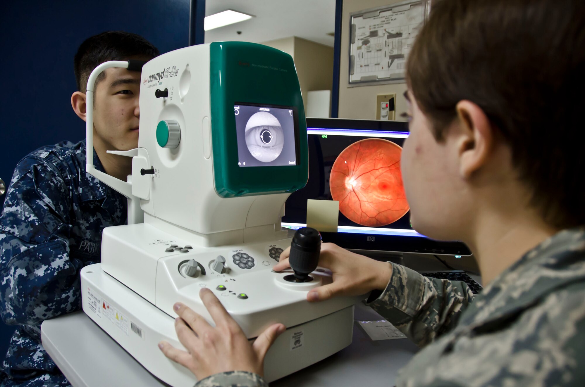 Airman 1st Class Jessica Borrowman, an optometry technician with the 126th Medical Group, uses a fundus camera to take a photo of a patient's retina June 12, 2014. Airman Borrowman is performing her two week annual training for the Illinois Air National Guard by assisting at the Branch Health Clinic, Naval Air Facility Atsugi, Japan. (Air National Guard photo by Senior Airman Laura Muehl)