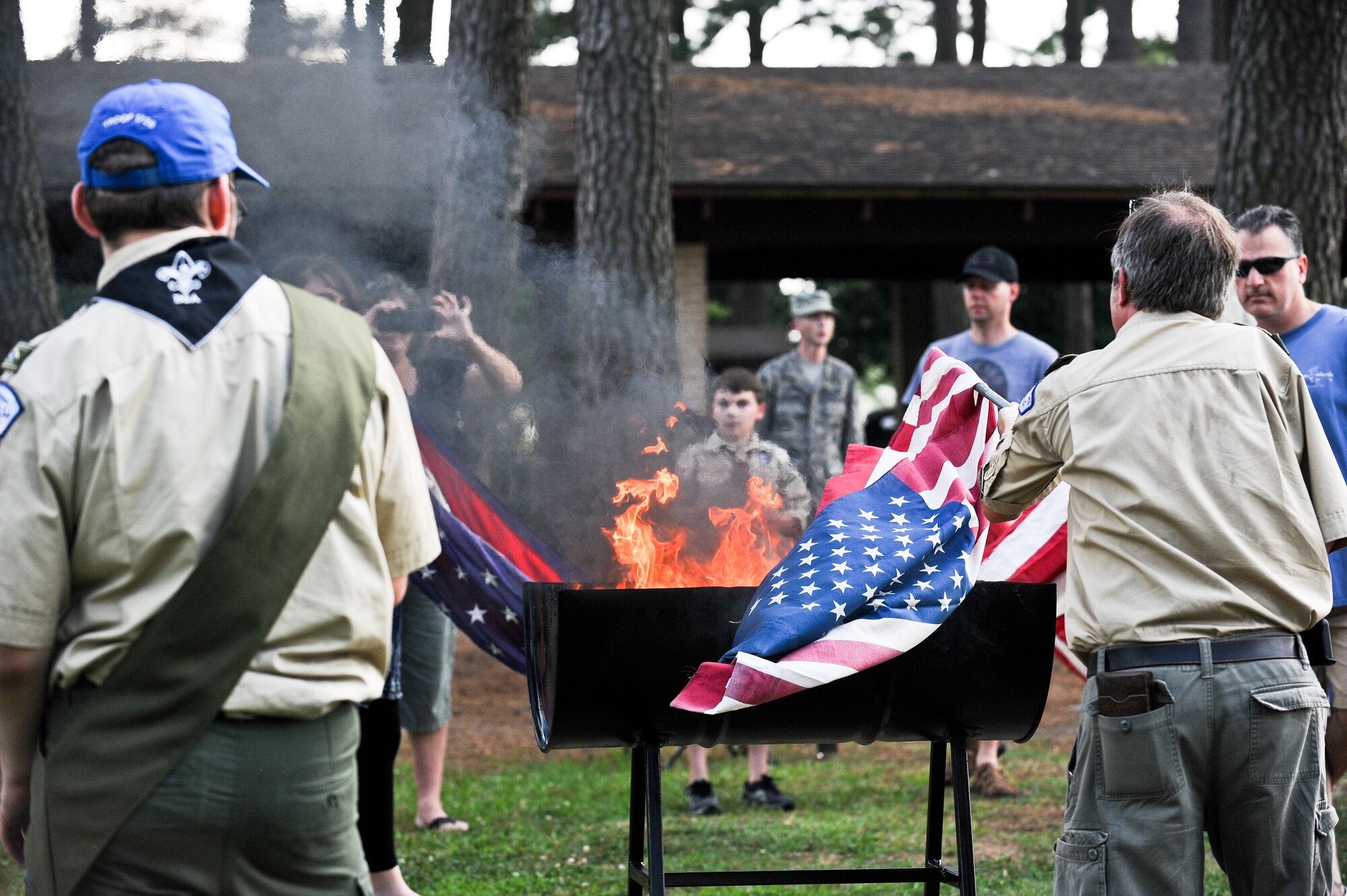 Bill Tilley, Troop 11 committee chair member, places a flag on the ceremony pyre June 14, 2014, at Seymour Johnson Air Force Base, North Carolina. The event was held on the same day the American flag was adopted in 1777, Flag Day. (U.S. Air Force photo/Airman 1st Class Aaron J. Jenne)