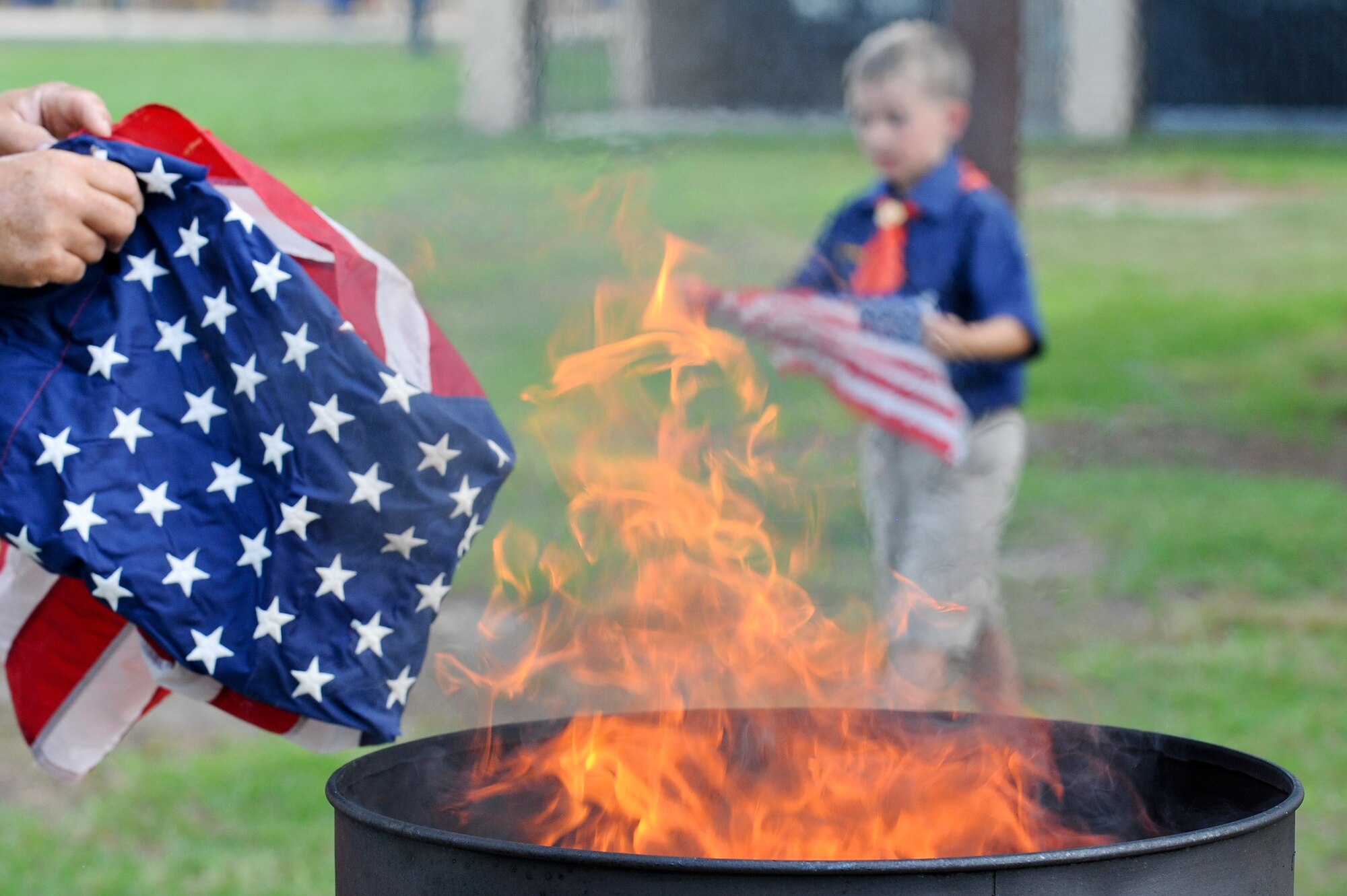 Scouts place flags on a fire during a flag retirement ceremony June 14, 2014, at Seymour Johnson Air Force Base, North Carolina. The 4th Fighter Wing honor guardsmen intend to make this an annual tradition. (U.S. Air Force photo/Airman 1st Class Aaron J. Jenne)