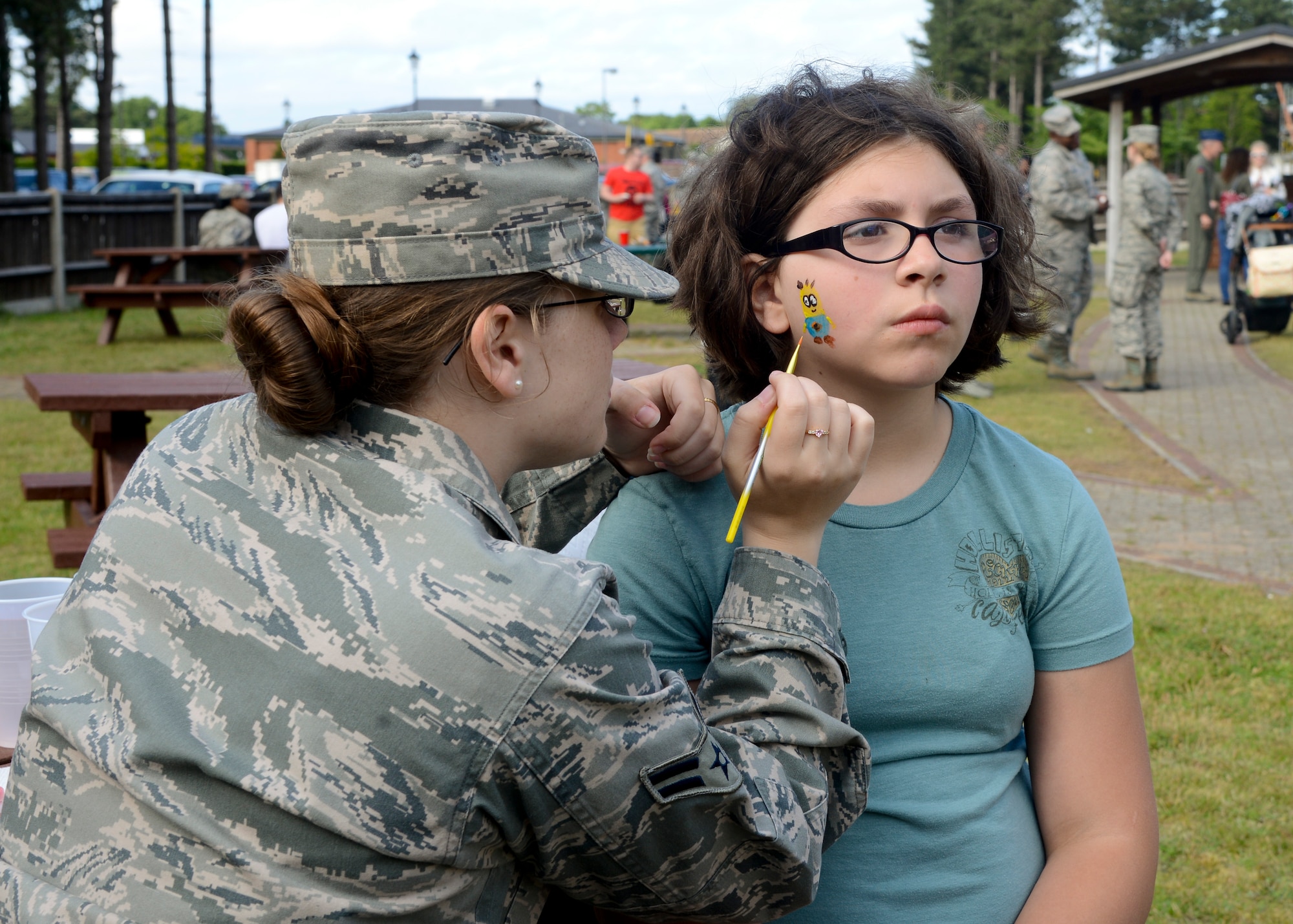 Jade Douglas, 11, daughter of U.S. Air Force Staff Sgt. Micah Douglas, 100th Civil Engineer Squadron power technician from Panama City, Fla., has her face painted by U.S. Air Force Airman 1st Class Ariel Pasciak, 100th Communications Squadron cyber transport technician from Severen, Md., at a Hearts Apart event June 18, 2014, at Heritage Park on RAF Mildenhall, England. The event was hosted by the 100th CS and featured a cook-out and games.  (U.S. Air Force photo/Airman 1st Class Victoria H. Taylor/Released)