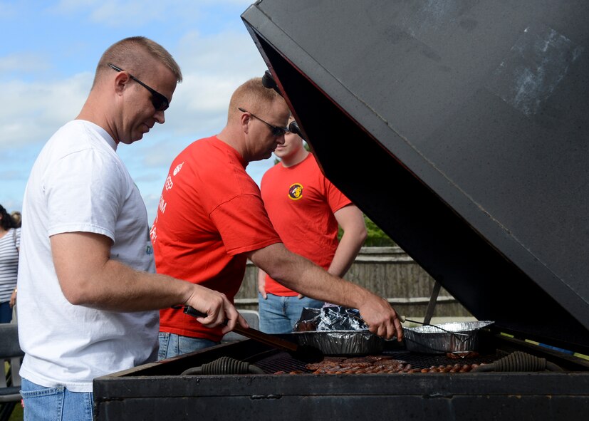 Team Mildenhall volunteers prepare food for families of deployed Airmen during a Hearts Apart event June 18, 2014, at Heritage Park on RAF Mildenhall, England. The 100th Communications Squadron hosted the event. (U.S. Air Force photo/Airman 1st Class Victoria H. Taylor/Released)