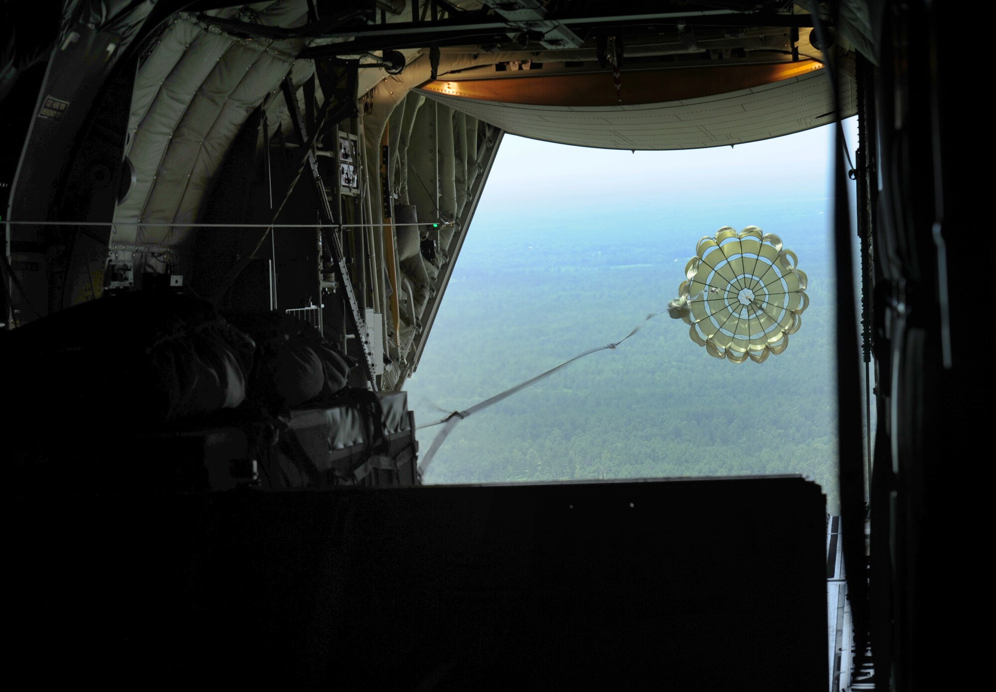 An Extracted Container Delivery System bundle exits a C-130J June 16, 2014, at Fort Polk, La. The XCDS bundles are engineered to allow the cargo loads to the exit the aircraft in a matter of seconds to reach ground forces faster and more accurately. (U.S. Air Force photo by Senior Airman Kaylee Clark)