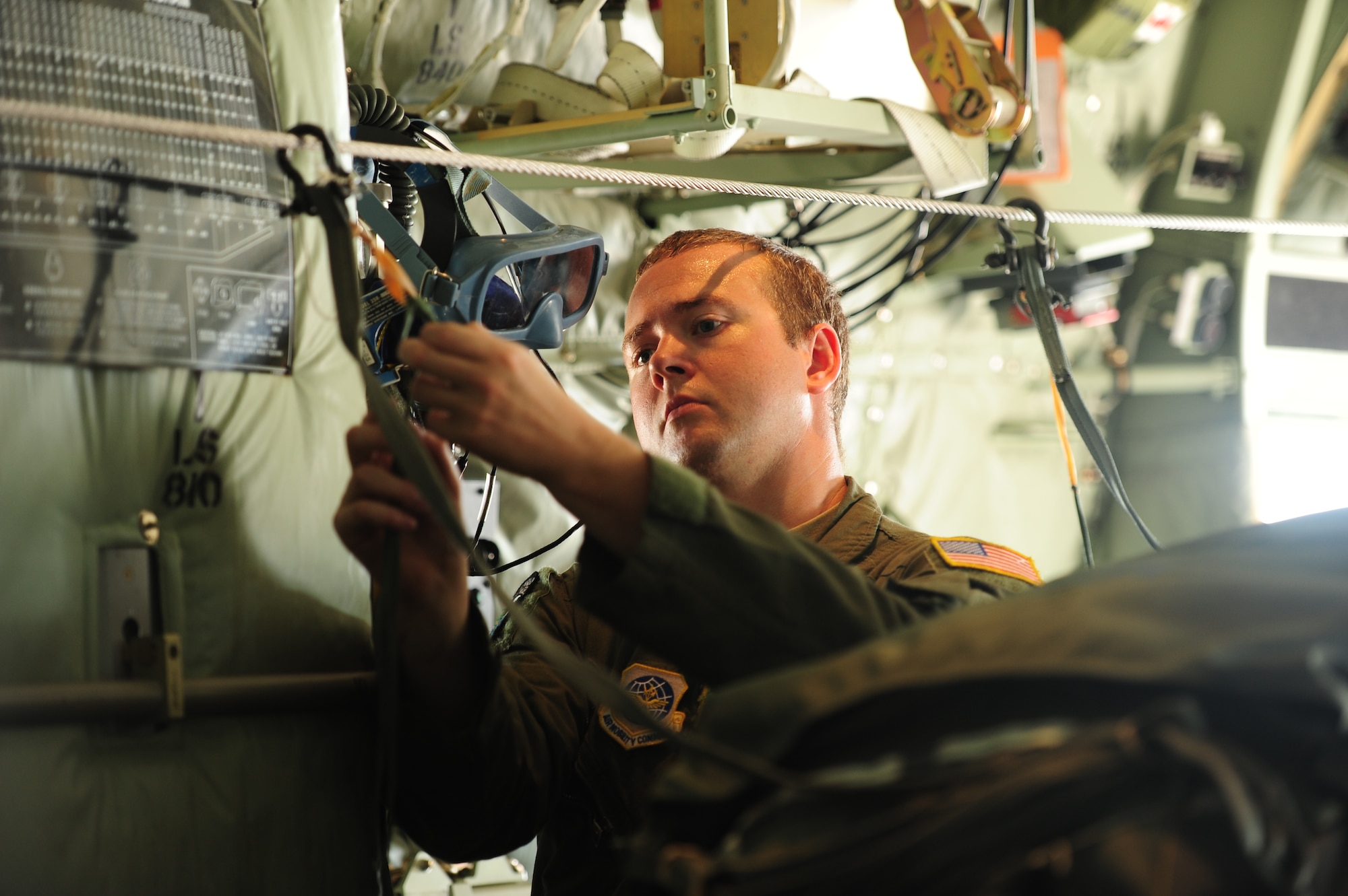 Senior Airman Jacob Vanderhalf, a 61st Airlift Squadron loadmaster, secures a cable in preparation for an airdrop June 16, 2014, at Little Rock Air Force Base, Ark. C-130’s from Little Rock AFB drop approximately 6,200 CDS bundles a year. (U.S. Air Force photo by Senior Airman Kaylee Clark)