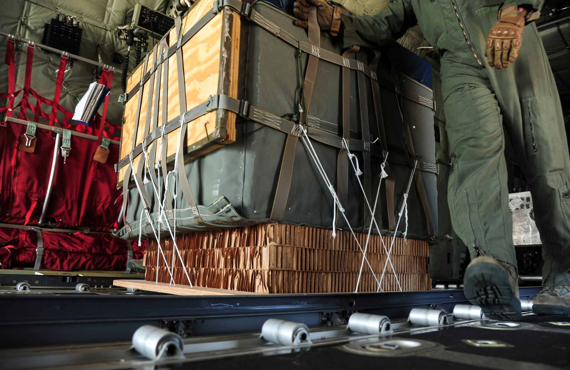Senior Airman Jacob Vanderhalf, a 61st Airlift Squadron loadmaster, slides a Container Delivery System bundle June 16, 2014, at Little Rock Air Force Base, Ark. Three base squadrons conducted the first-ever Extracted Container Delivery System airdrops to support the Green Flag Little Rock exercise. (U.S. Air Force photo by Senior Airman Kaylee Clark)