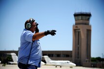 Herman Hidalgo, 47th Maintenance Directorate aircraft servicer, marshals a T-1A Jayhawk at the flight line on Laughlin Air Force Base, Texas, June 10, 2014. The T-1A Jayhawk is a medium-range, twin-engine jet trainer used in the advanced phase of specialized undergraduate pilot training for students selected to fly airlift or tanker aircraft. (U.S. Air Force photo/Staff Sgt. Steven R. Doty)(Released)