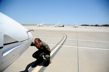 Capt. Richard Loesch III, 86th Flying Training Squadron instructor pilot, inspects the T-1A Jayhawk nose cone and front landing gear at the flight line on Laughlin Air Force Base, Texas, June 10, 2014. Laughlin, home to the Air Education and Training Command 47th Flying Training Wing, is the 5th busiest airfield in the Air Force and graduates the most pilots from a training base. (U.S. Air Force photo/Staff Sgt. Steven R. Doty)(Released)