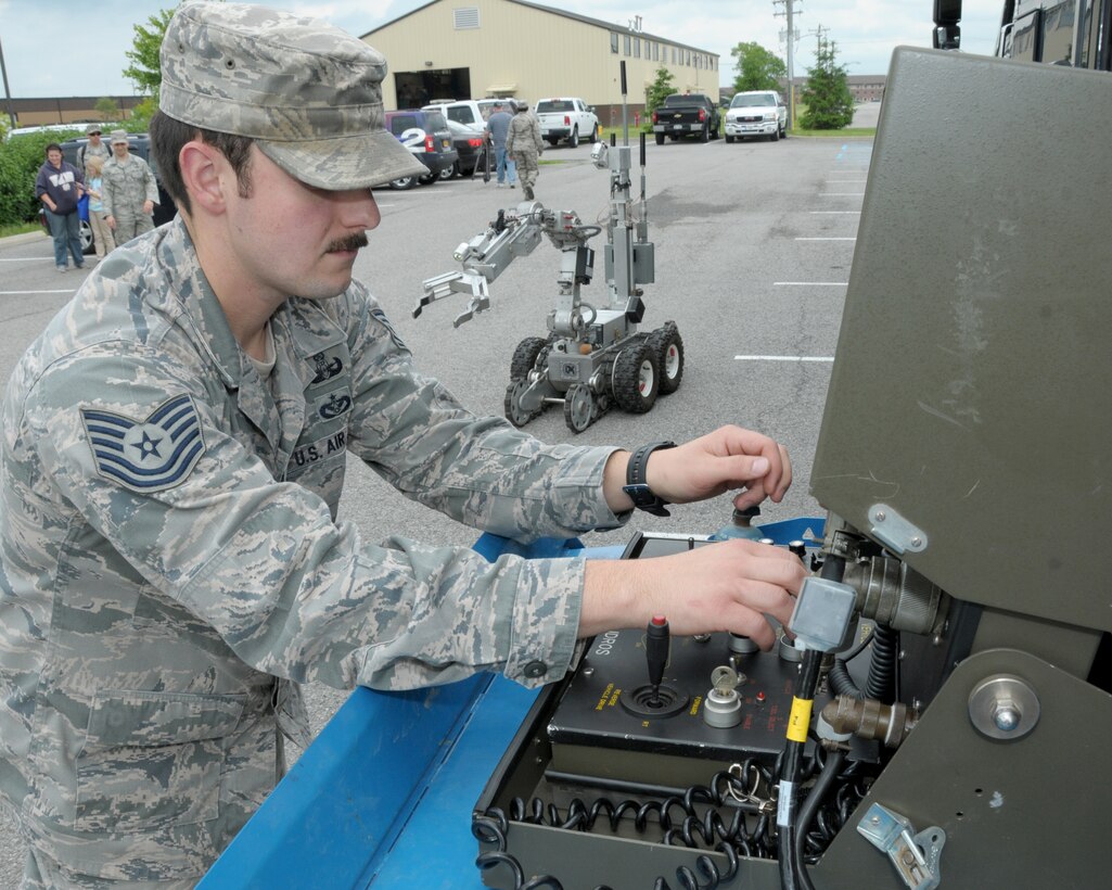 Tech. Sgt. Kyle Spalding, explosive ordnance disposal (EOD) specialist, 914th Civil Engineer Squadron, operates an Air Force F6A Robot (background) by remote control at the Niagara Falls Air Reserve Station, N.Y., June 12, 2014. Spalding was demonstrating the robot’s capabilities and answering questions about the EOD mission during the NFARS Fire Department’s Open House.  (U.S. Air Force Photo by Peter Borys)