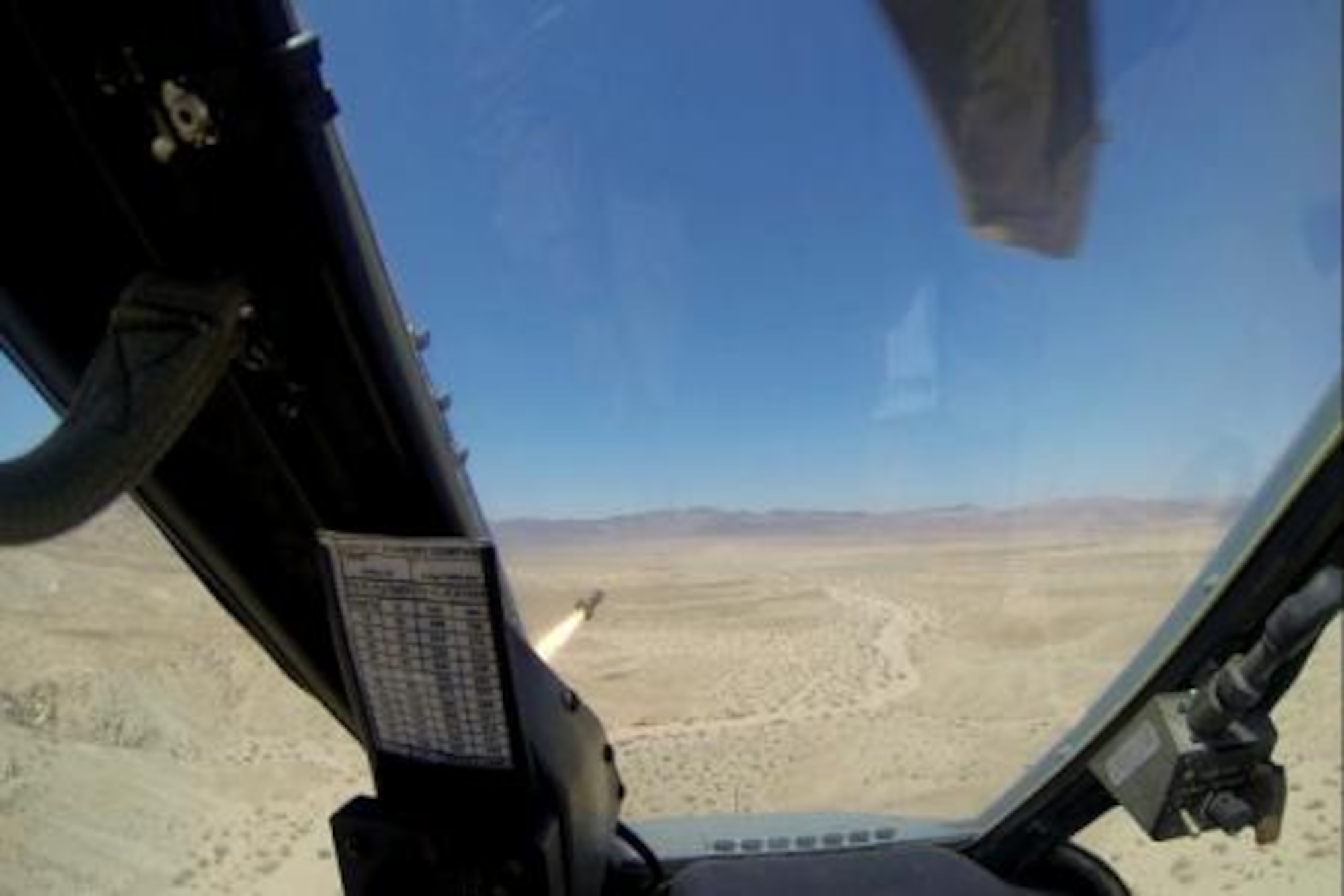 Major Dennis "Pez" Pyszczymuka fires a Hellfire missile into a mock enemy position as part of the Integrated Training Exercise at Marine Corps Air Ground Combat Center Twentynine Palms. Ordnance Marines loaded and armed the rocket minutes before, and will dearm the aircraft for safety when Pez lands it on the runway. (Marine photo by Sgt. Russell Midori)