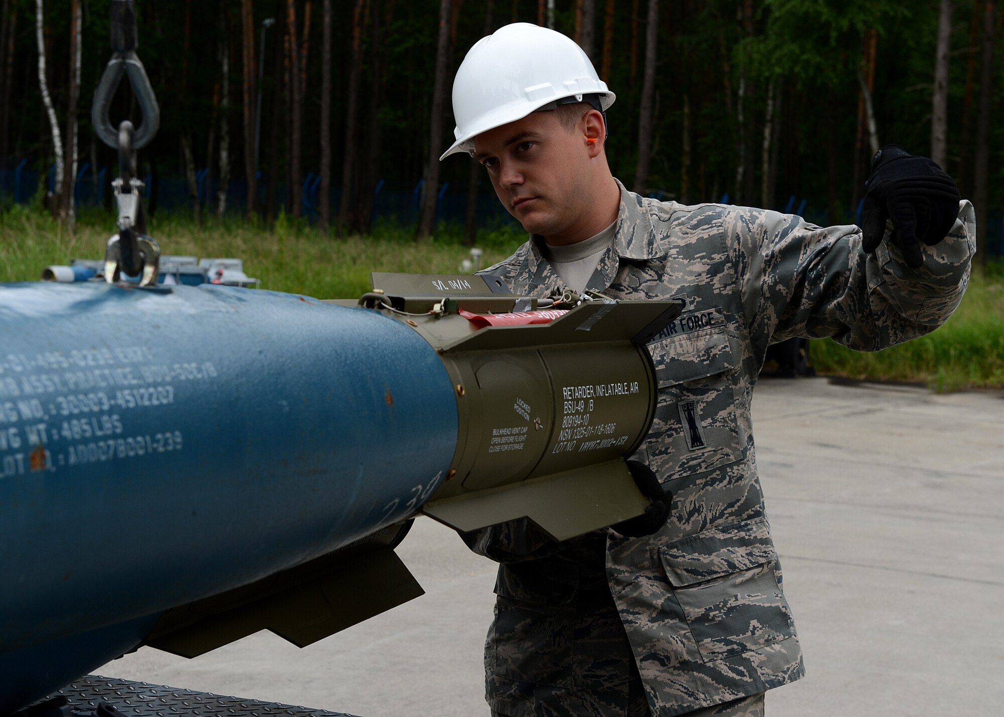 U.S. Air Force Senior Airman Timothy Greening, 52nd Equipment Maintenance Squadron precision guided munitions crew member from Norman, Okla., lowers a Bomb Drop Unit-50 onto a transport trailer at Lask Air Base, Poland, June 12, 2014. Airmen from the 52nd EMS of Spangdahlem Air Base, Germany, provided training ammunition to pilots for close-air-support mission training. In addition, their contributions also supported multinational exercises EAGLE TALON and BALTOPS 14, which aimed to increase interoperability and strengthen NATO partnerships. (U.S. Air Force photo by Airman 1st Class Kyle Gese/Released)