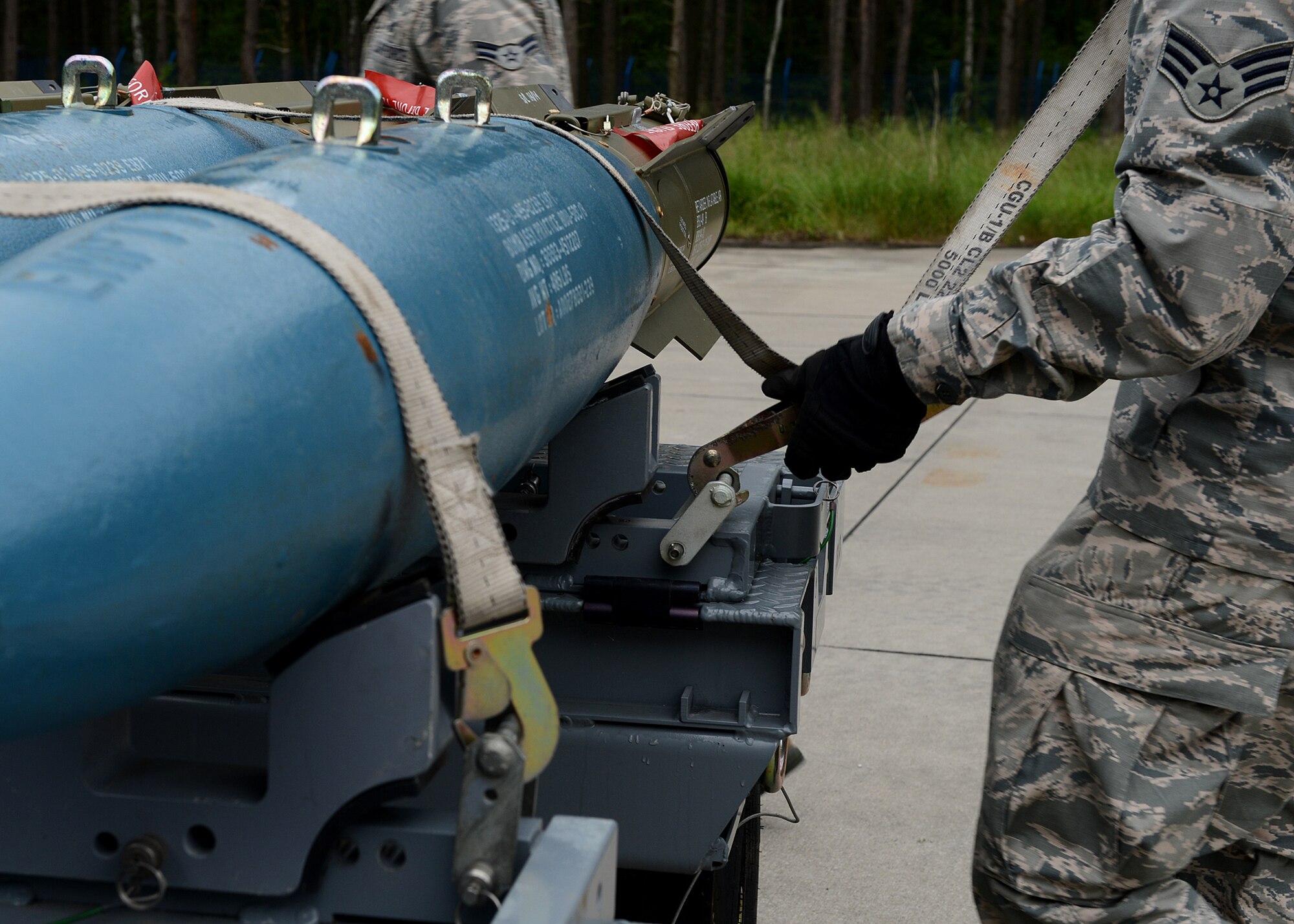 U.S. Air Force Senior Airman Timothy Greening, 52nd Equipment Maintenance Squadron precision guided munitions crew member from Norman, Okla., secures multiple Bomb Drop Unit-50 onto a transport trailer at Lask Air Base, Poland, June 12, 2014. The 52nd EMS from Spangdahlem Air Base, Germany, supported the U.S. Aviation Detachment Rotation 14-3 and participated in exercises EAGLE TALON and BALTOPS 14 by providing training ammunition for pilots. The multinational exercises aimed to increase interoperability with foreign nations and strengthen NATO partnerships. (U.S. Air Force photo by Airman 1st Class Kyle Gese/Released)