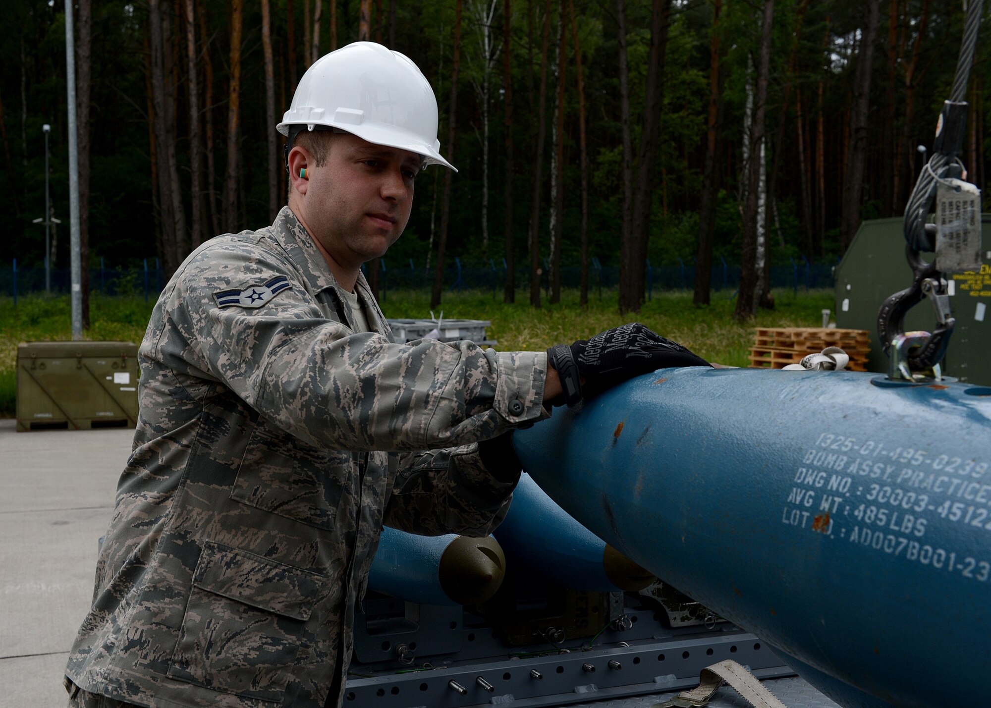 U.S. Air Force Airman 1st Class Joseph Stoffer, 52nd Equipment Maintenance Squadron conventional maintenance crew member from Warsaw, N.Y., guides a Bomb Drop Unit-50 onto a transport trailer at Lask Air Base, Poland, June 12, 2014. Nearly 400 Airmen from Spangdahlem Air Base, Germany, and 18 F-16 Fighter Falcon fighter aircraft supported the U.S. Aviation Detachment Rotation 14-3 and participated in exercises EAGLE TALON and BALTOPS 14. (U.S. Air Force photo by Airman 1st Class Kyle Gese/Released)