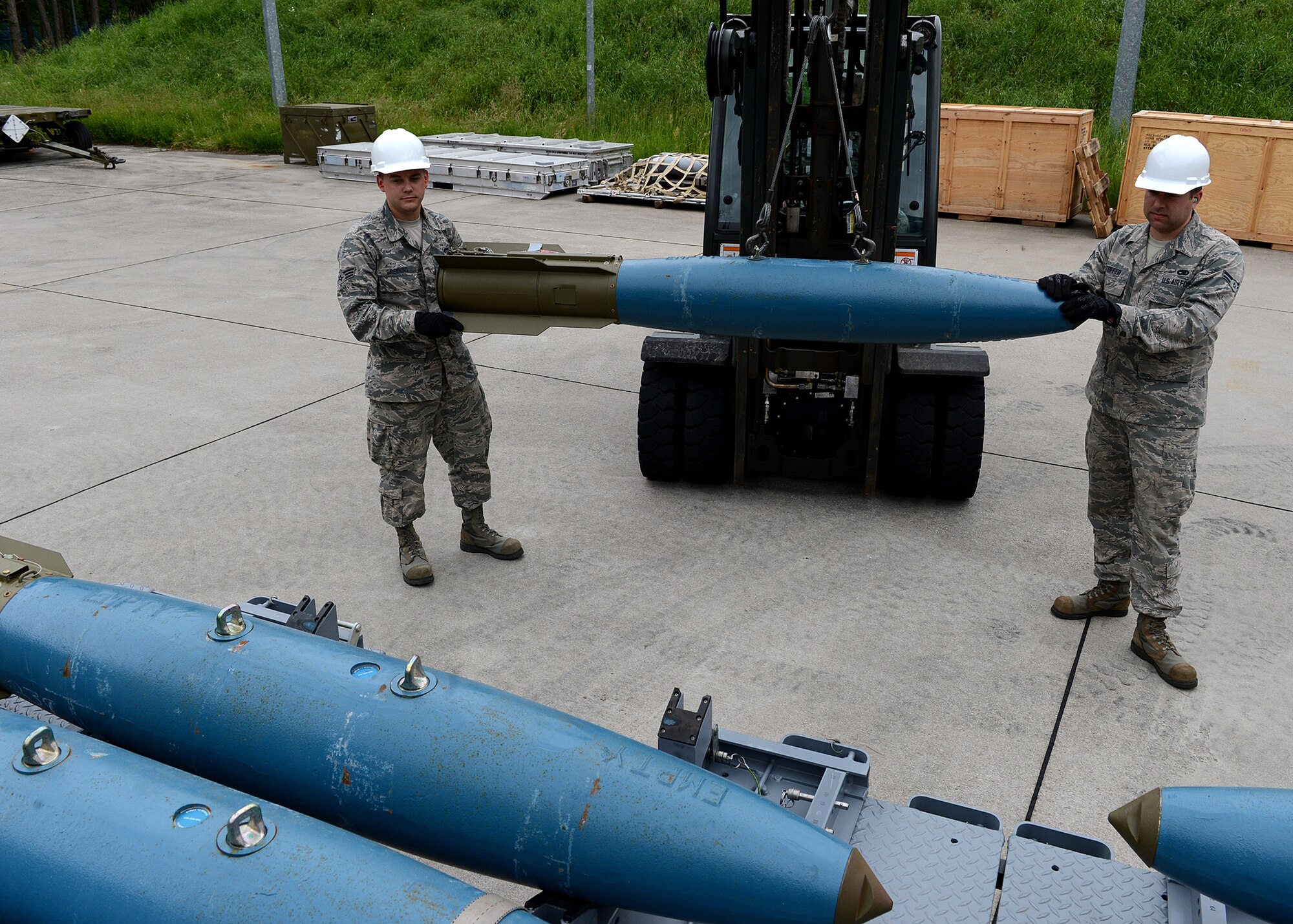 U.S. Air Force Senior Airman Timothy Greening, 52nd Equipment Maintenance Squadron precision guided munitions crew member from Norman, Okla., and Airman 1st Class Joseph Stoffer, 52nd EMS conventional maintenance crew member from Warsaw, N.Y., move a Bomb Drop Unit-50 training explosive to a transport trailer at Lask Air Base, Poland, June 12, 2014. Eighteen U.S. Air Force F-16 Fighting Falcon fighter aircraft from Spangdahlem Air Base, Germany, used training munitions during exercises BALTOPS 14 and EAGLE TALON. While increasing bilateral defense ties with host nation partners, the exercises also trained pilots in a combat environment to build relationships with NATO allies. (U.S. Air Force photo by Airman 1st Class Kyle Gese/Released)