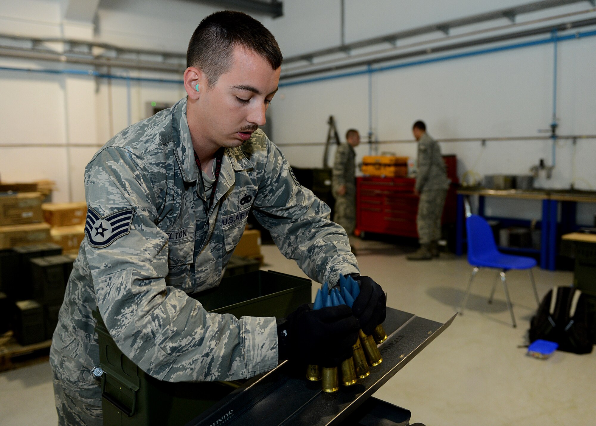 U.S. Air Force Staff Sgt. Jonathan Shelton, 52nd Equipment Maintenance Squadron munitions storage crew chief from Bassett, Va., places 20 mm target practice rounds on a replenisher table at Lask Air Base, Poland, June 12, 2014. Airmen from the 52nd EMS of Spangdahlem Air Base, Germany, supported exercises BALTOPS 14 and EAGLE TALON, which aimed to familiarize pilots with foreign procedures and strengthen NATO partnerships. (U.S. Air Force photo by Airman 1st Class Kyle Gese/Released)