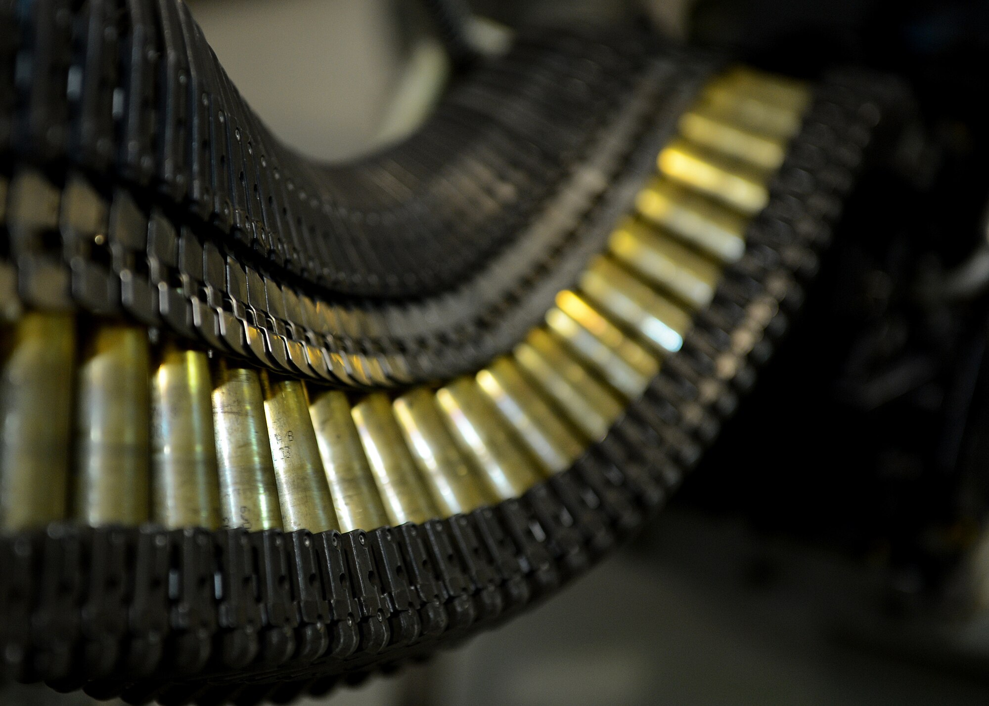 Airmen feed 20 mm target practice rounds into a universal ammunition loading system at Lask Air Base, Poland, June 12, 2014. Ammunition was transferred to the aircraft using the UAL, which can hold approximately 2,100 rounds. The ammo for 18 U.S. Air Force F-16 Fighting Falcon fighter aircraft, from Spangdahlem Air Base, Germany, was used during Polish-led EAGLE TALON and U.S. Navy-led BALTOPS 14 to train pilots for future close-air-support missions. (U.S. Air Force photo by Airman 1st Class Kyle Gese/Released)